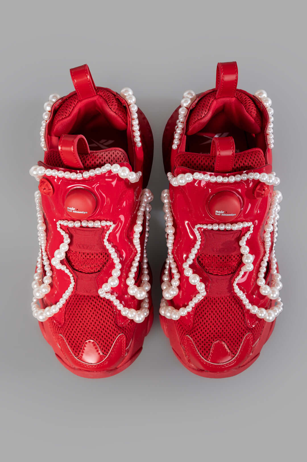 Noir Kei Ninomiya x Reebok Pearl-embellished Sneakers in Red, featuring pearl details and dual pull-tabs, top view.
