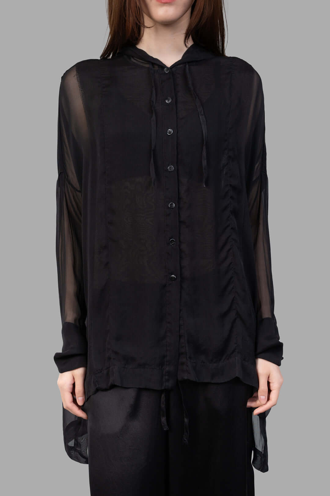 Masnada Hooded Shirt in black, featuring a translucent design, button closure, and drawstring hem, worn on a model.