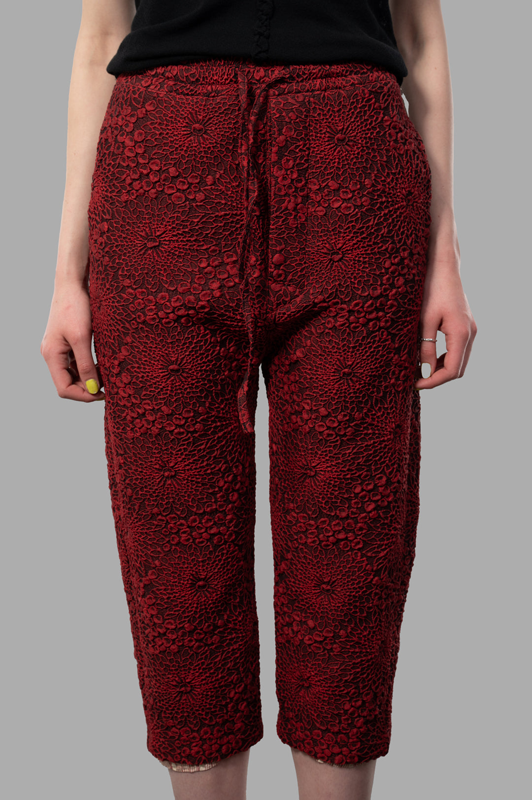 Marc Point Floral Capri Pants showcasing a textured floral design, red color, and relaxed fit, modeled from the front.