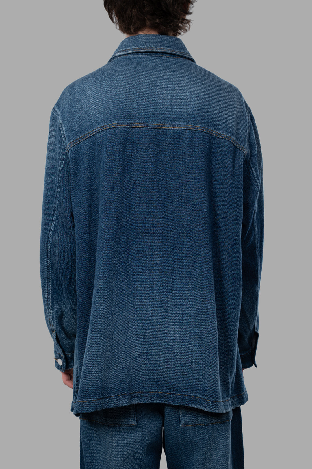 Vein Faded Denim Jacket viewed from the back, showcasing relaxed fit and faded blue wash texture.