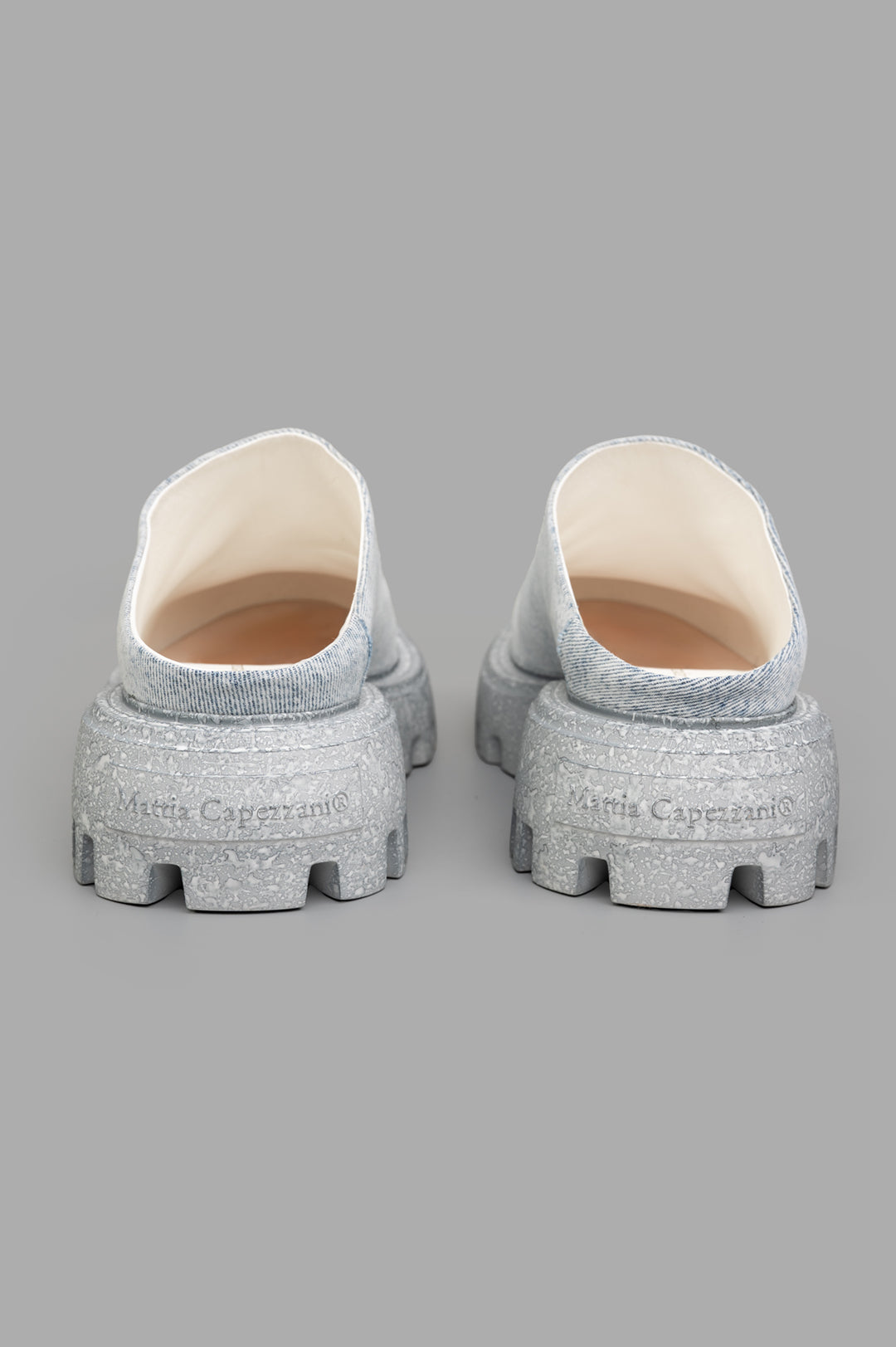 Mattia Capezzani Denim Mules showcasing a sculptural design with a gray sole and soft denim upper, perfect for stylish comfort.