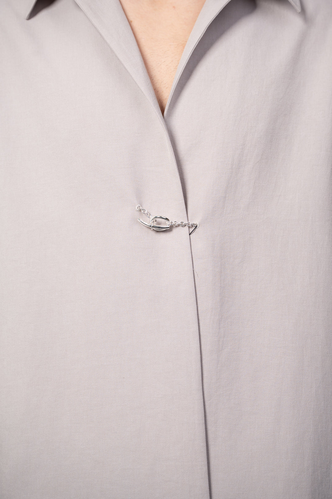 Attachment Twill Chain Shirt in beige featuring a close-up of a stylish chain detail on the collar. Made from cotton, linen.