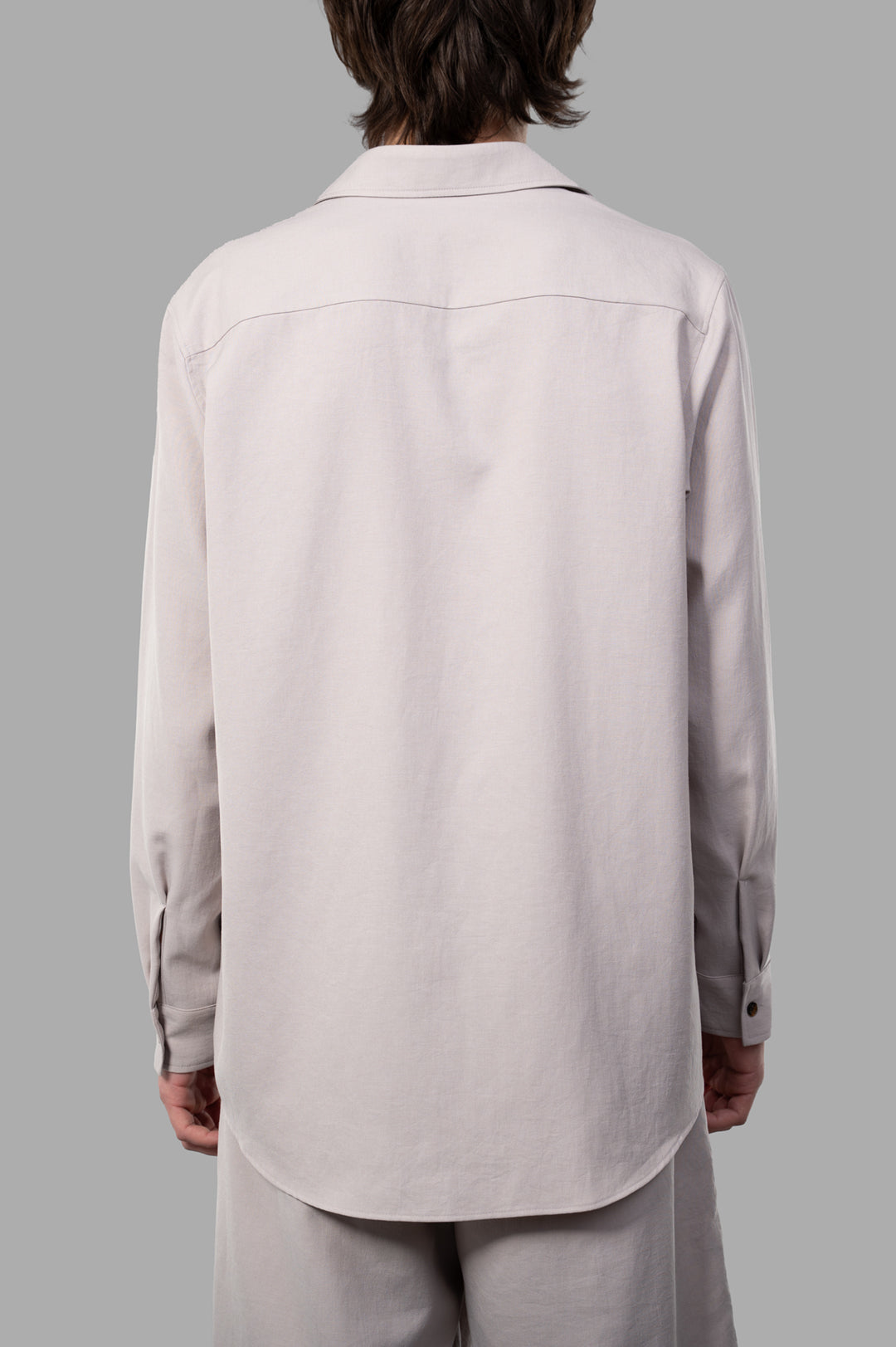 Attachment Twill Chain Shirt displayed from the side, highlighting its relaxed fit and soft beige fabric composition.