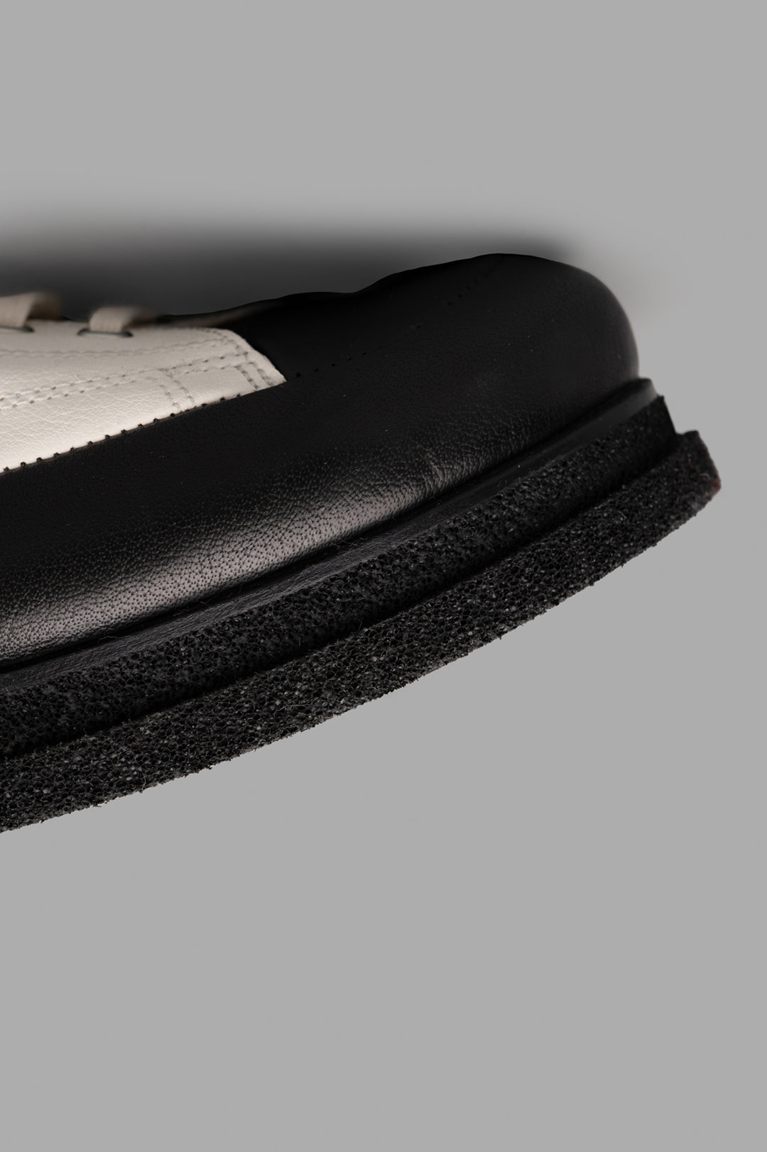 Shoto Color-block Shoes featuring a textured black and white leather upper with a unique sole design detail.