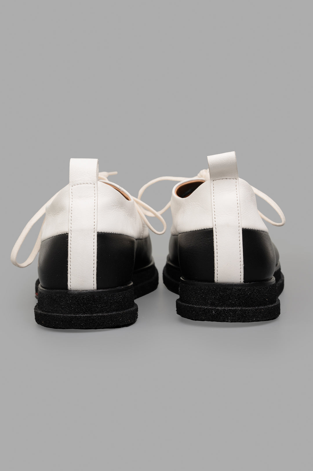 **Alt Text:** Shoto Color-block Shoes in white and black, showcasing the back view with artisanal leather detail and unique craftsmanship.