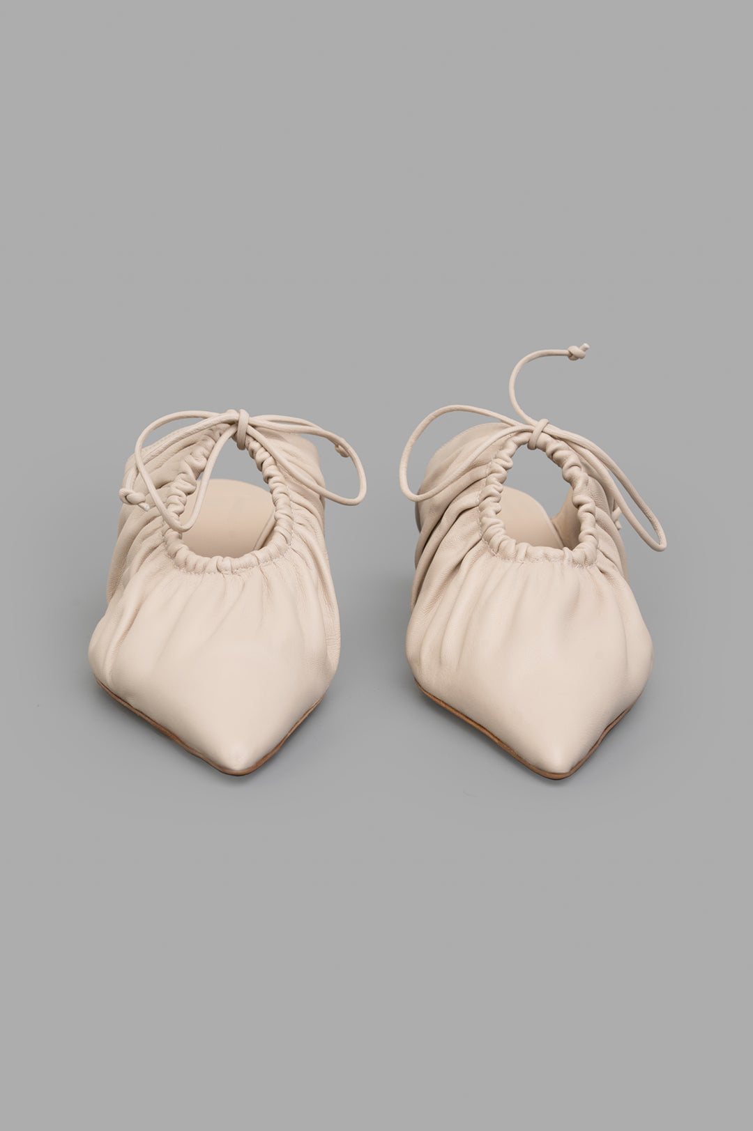 By Malene Birger Masey Leather Mules in ecru, showcasing a smooth goat leather design with draped cut-out and bow.