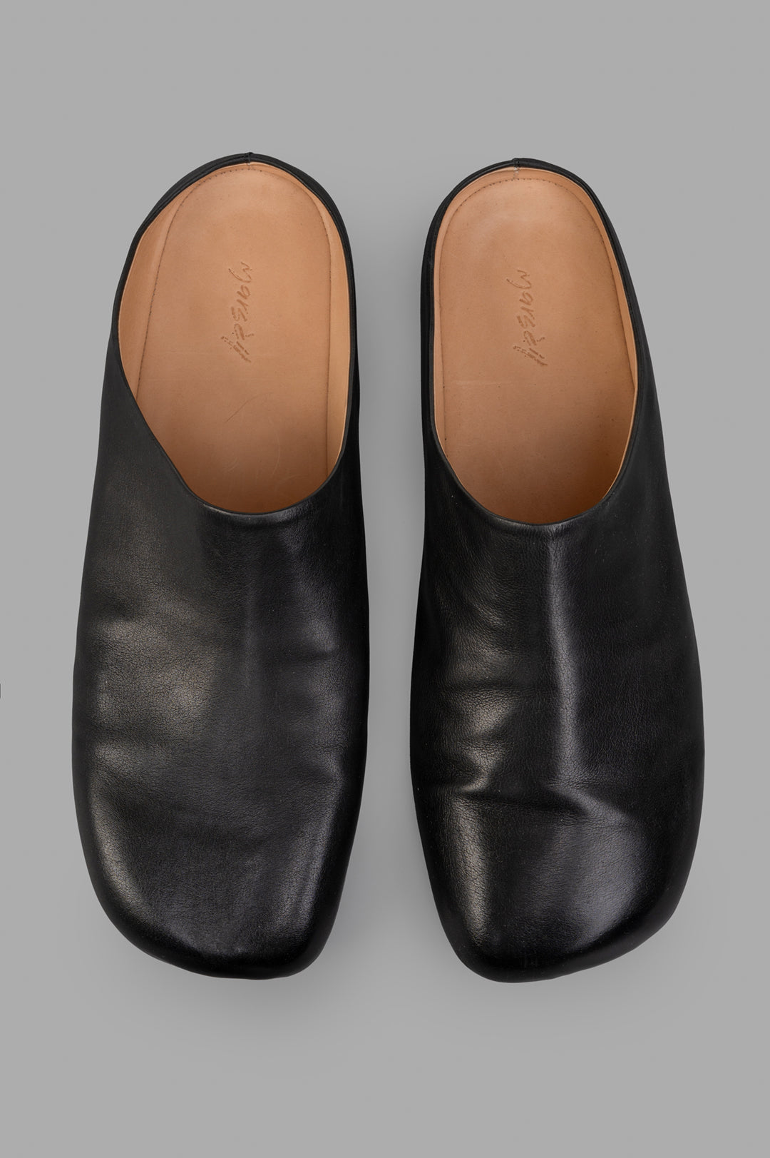 Marsèll Leather Mules in black, showcasing a sleek top view with a smooth leather finish and artisanal detailing.