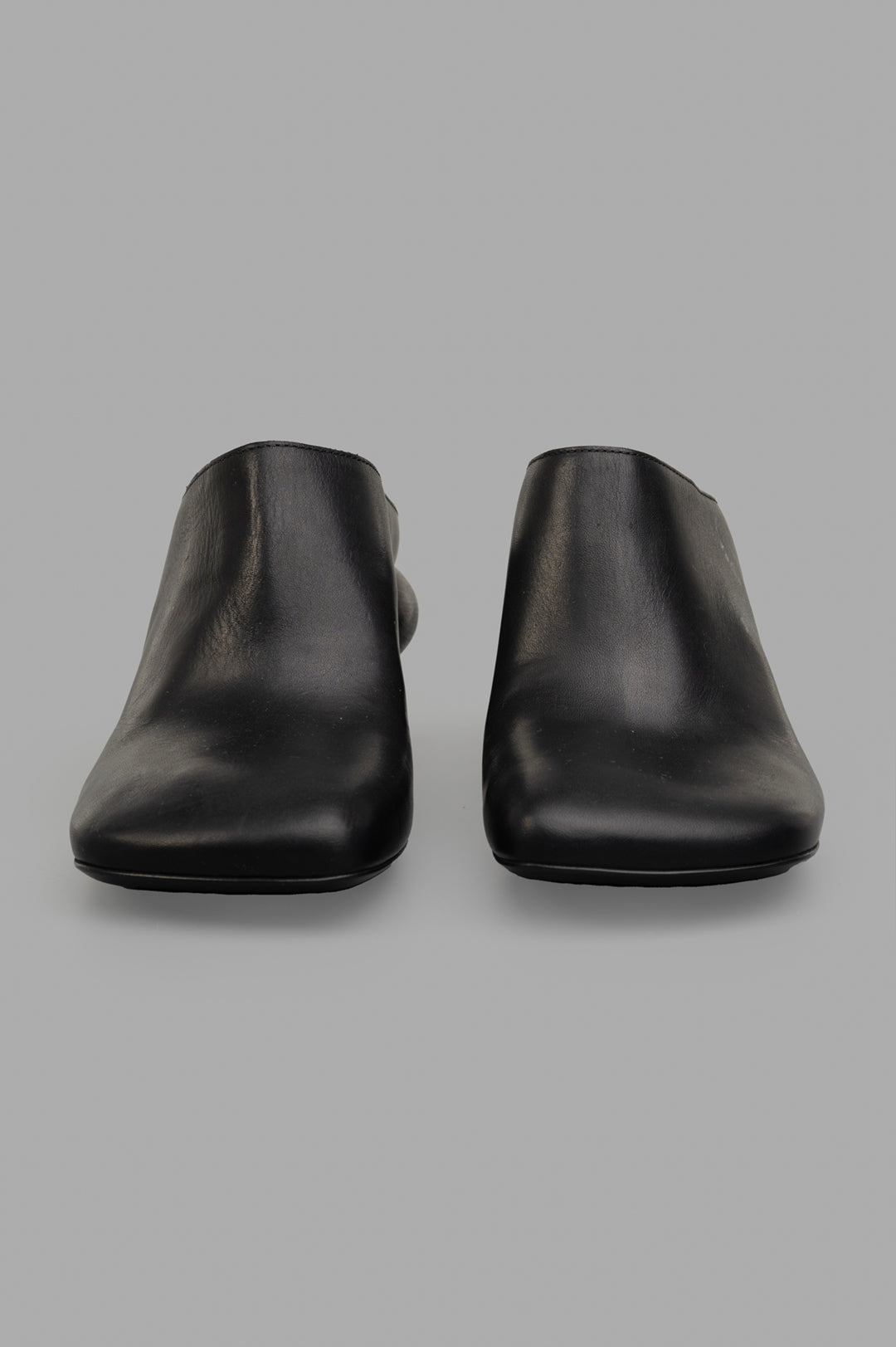 Uma Wang Stone Mules in Black, showcasing a classic square toe design and smooth calf leather from a frontal view.