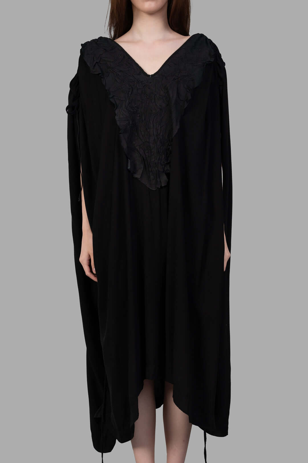 Isaac Sellam Leather-detail Dress featuring a striking V-neckline and elegant structure, worn by a model.