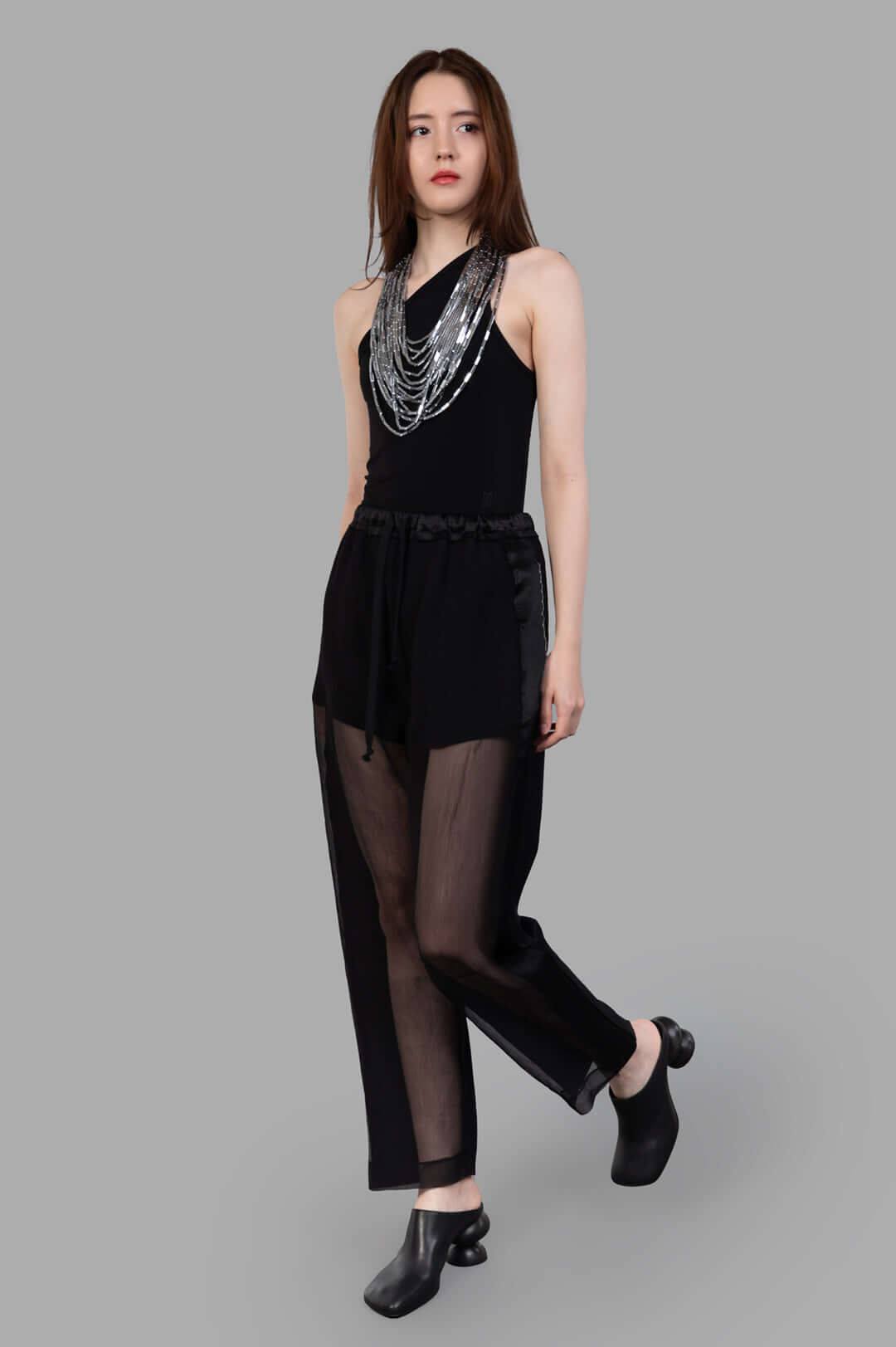 Giovanni Cavagna semi-sheer pants in black silk, front view on model, showcasing elegant and innovative design.