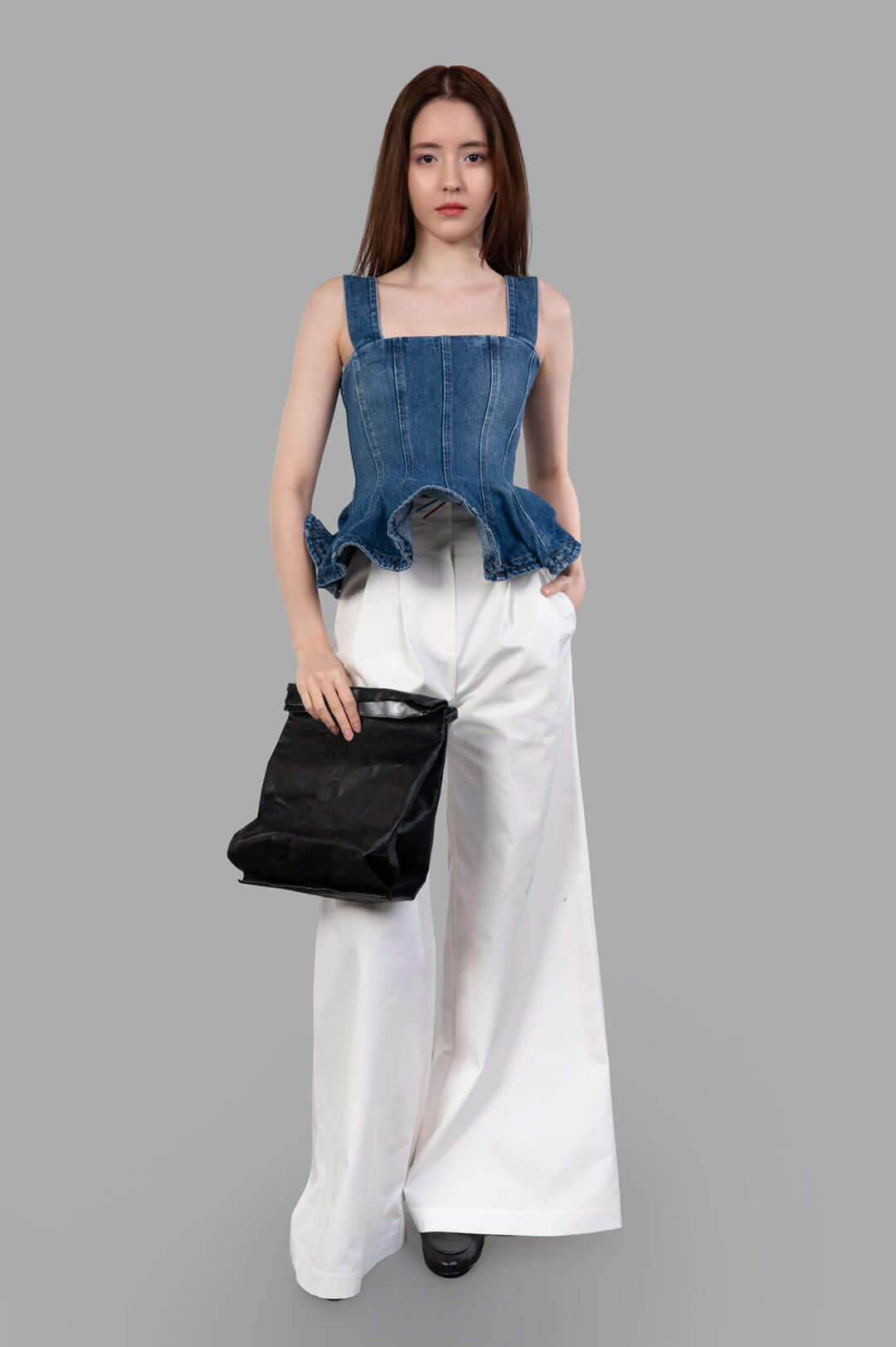 MSGM Denim Peplum Top on model, featuring square neckline and ruffled hem, paired with white wide-leg trousers.