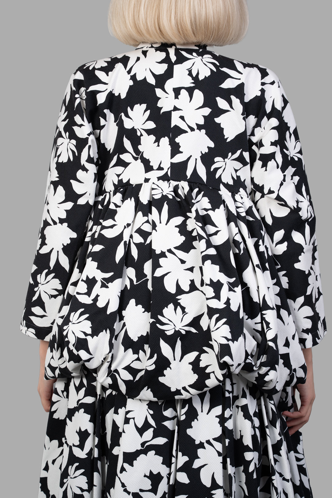 Comme des Garçons Floral-print Pleated Jacket, showcasing a black and white floral design from the back with loose fit and pleats.