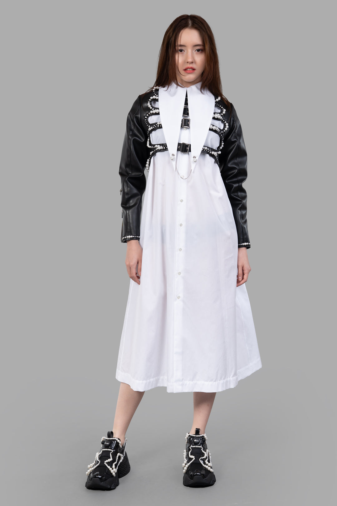 Noir Kei Ninomiya Pearl-Detailed Jacket on model, showcasing black faux leather with pearl accents and adjustable pin-buckle.