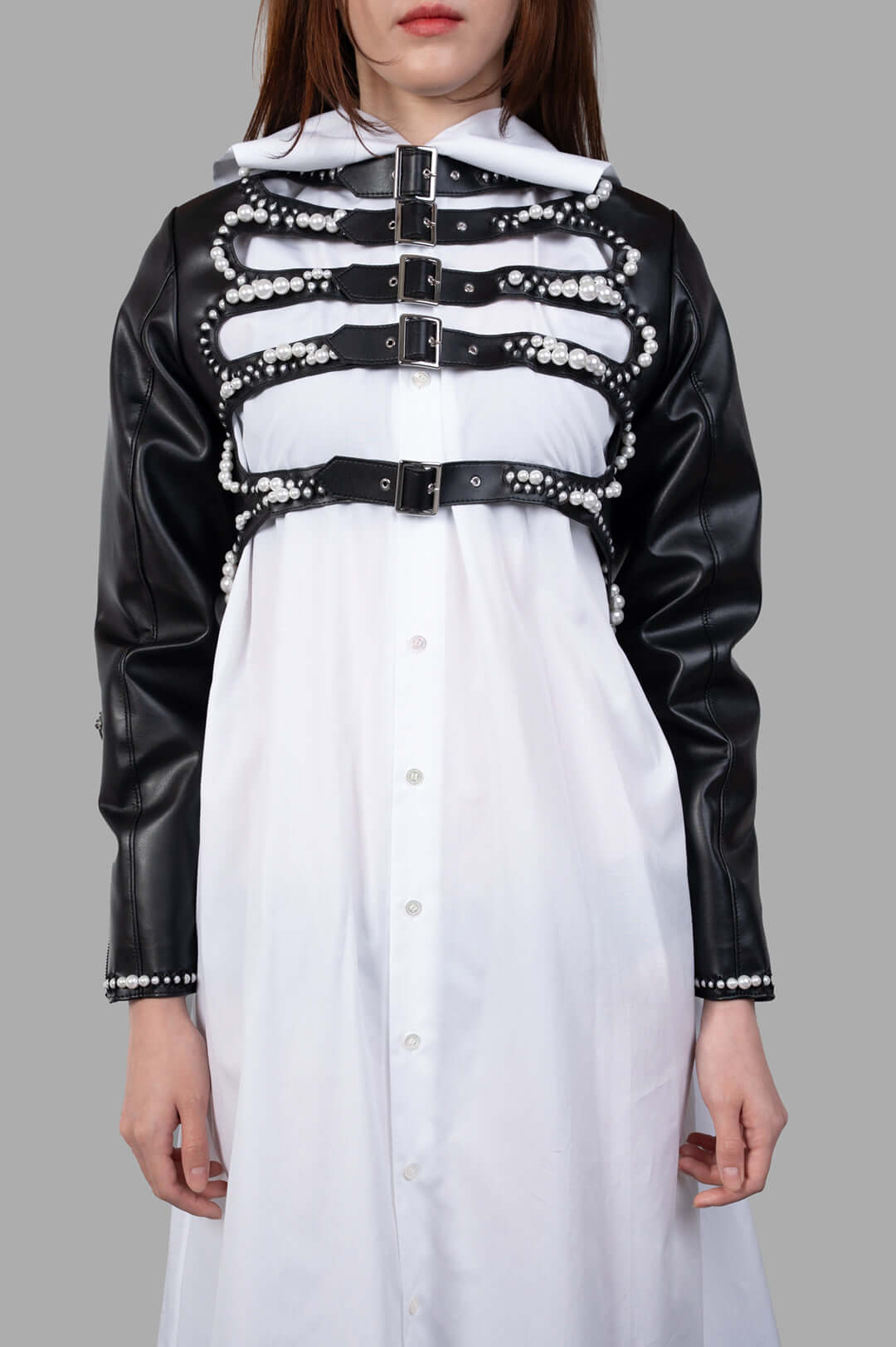 Noir Kei Ninomiya Pearl-Detailed Jacket showcasing front view with pearl embellishments and adjustable straps on a model.