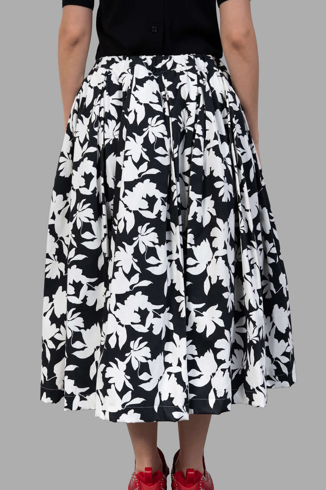 Comme des Garçons Floral-print Skirt showcasing a black and white floral design, with side pockets and tulle lining on model.