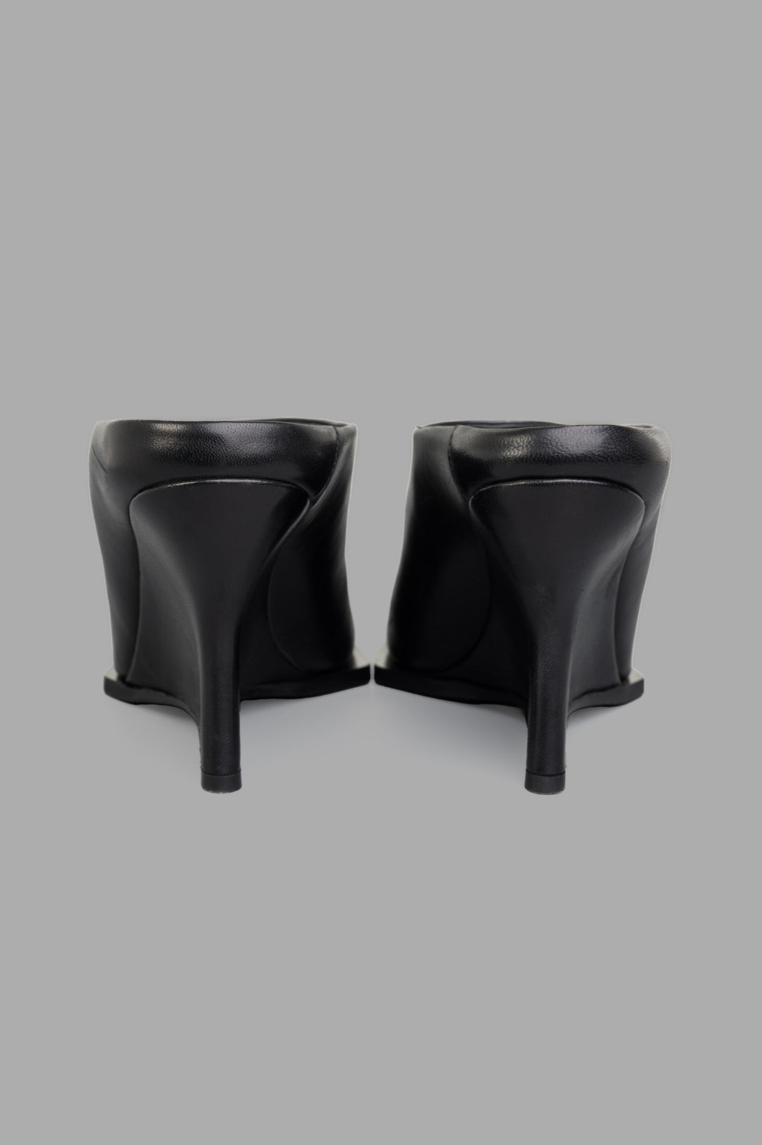Mattia Capezzani Wedge Mules in black leather, showcasing sculptural design from the back with elegant high heels.