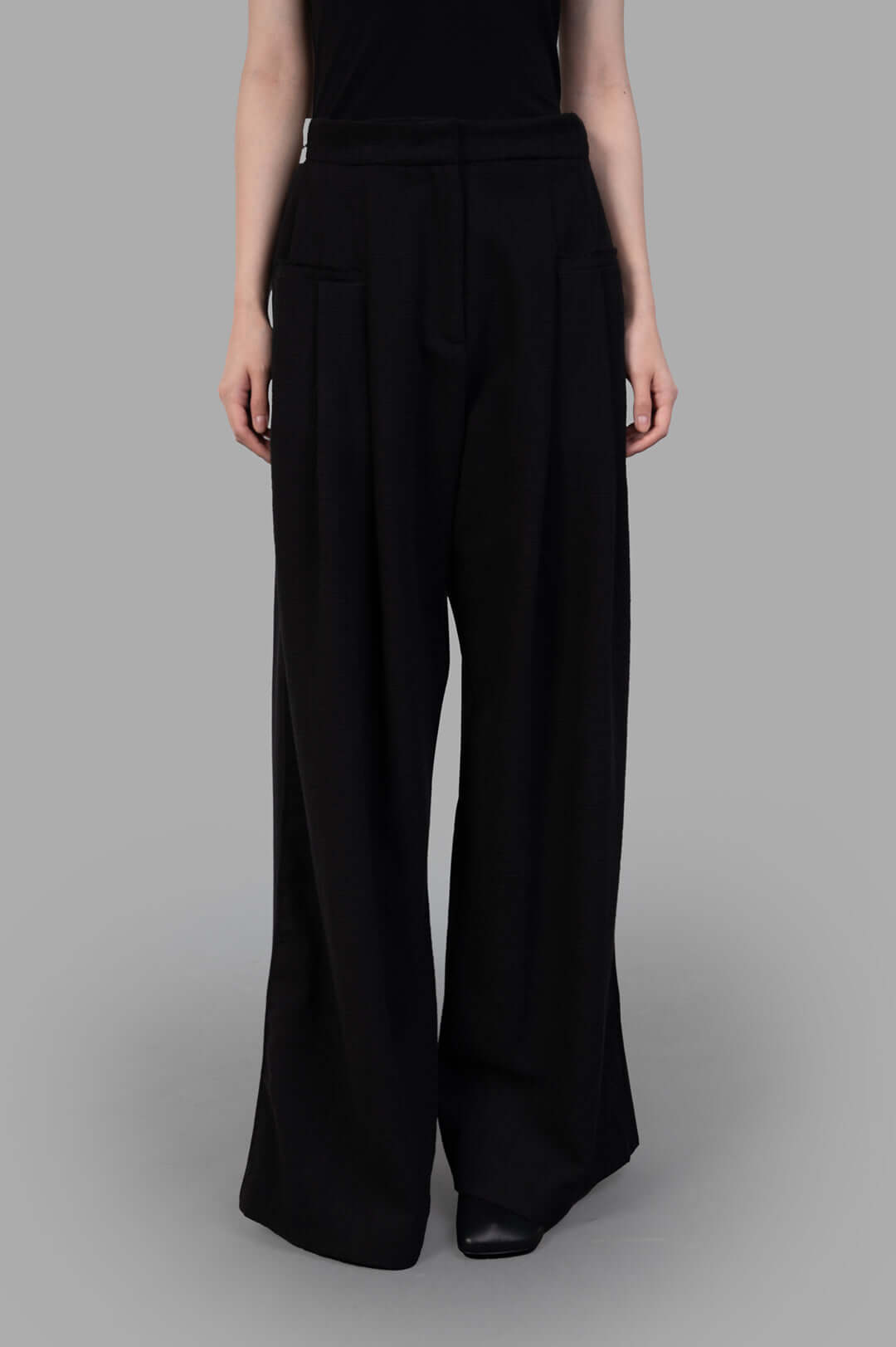 Giovanni Cavagna Wide-leg Trousers showcasing a relaxed fit with front pockets, made from soft black linen fabric.