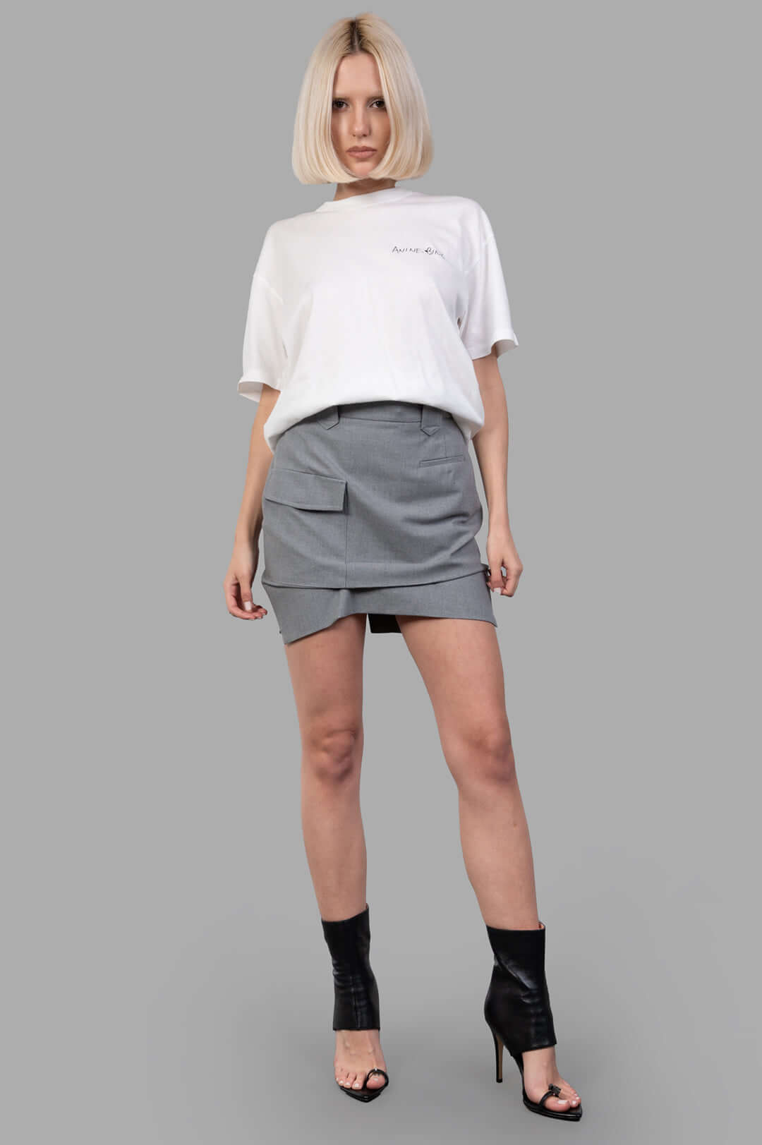 Vivienne Westwood grey Pleated Cargo Mini Skirt front view on model, featuring front button and zip, cotton fabric.