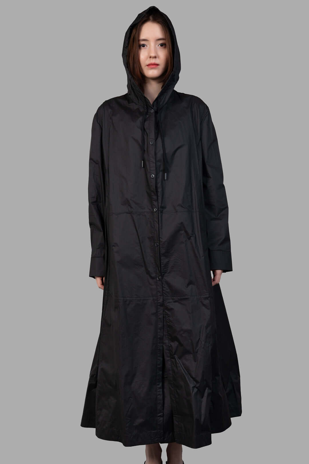 Masnada 2-in-1 Parka, black hooded long coat, front view on-model, button-front with drawstrings.