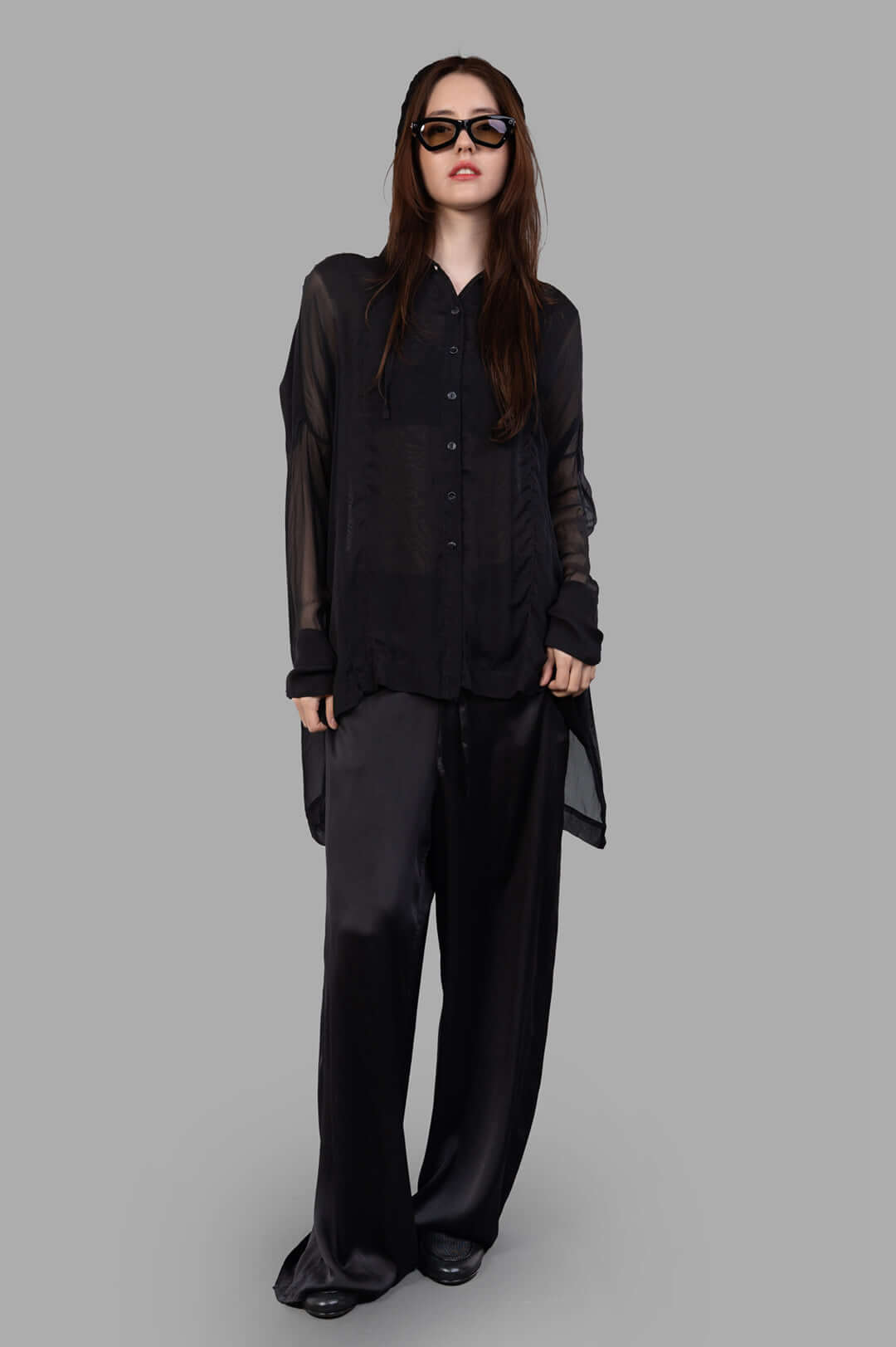 Masnada black silk hooded shirt on-model view, featuring translucent fabric, button closure, and asymmetrical hem.