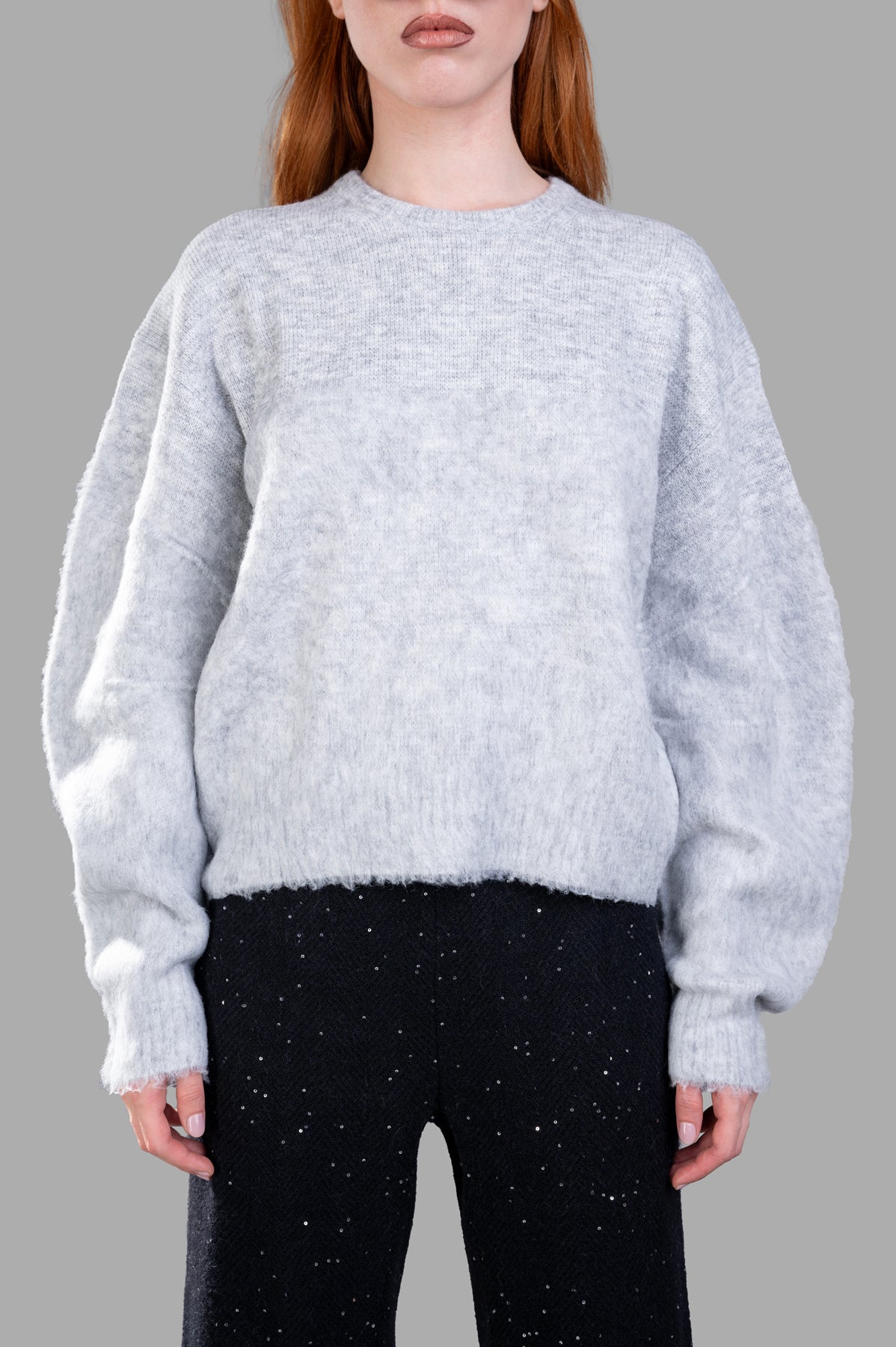 Helmut Lang Brushed Apex Sweater featured on model with oversized sleeves in soft grey, styled with dark pants.