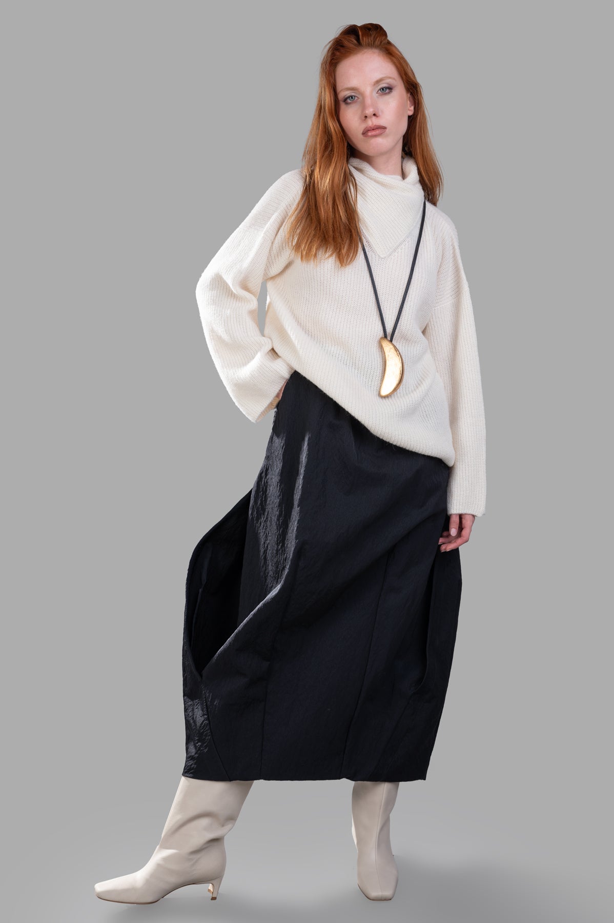 Gentry Portofino Cream Sweater: model wearing cozy knit with asymmetric turtleneck, showcasing modern elegance.