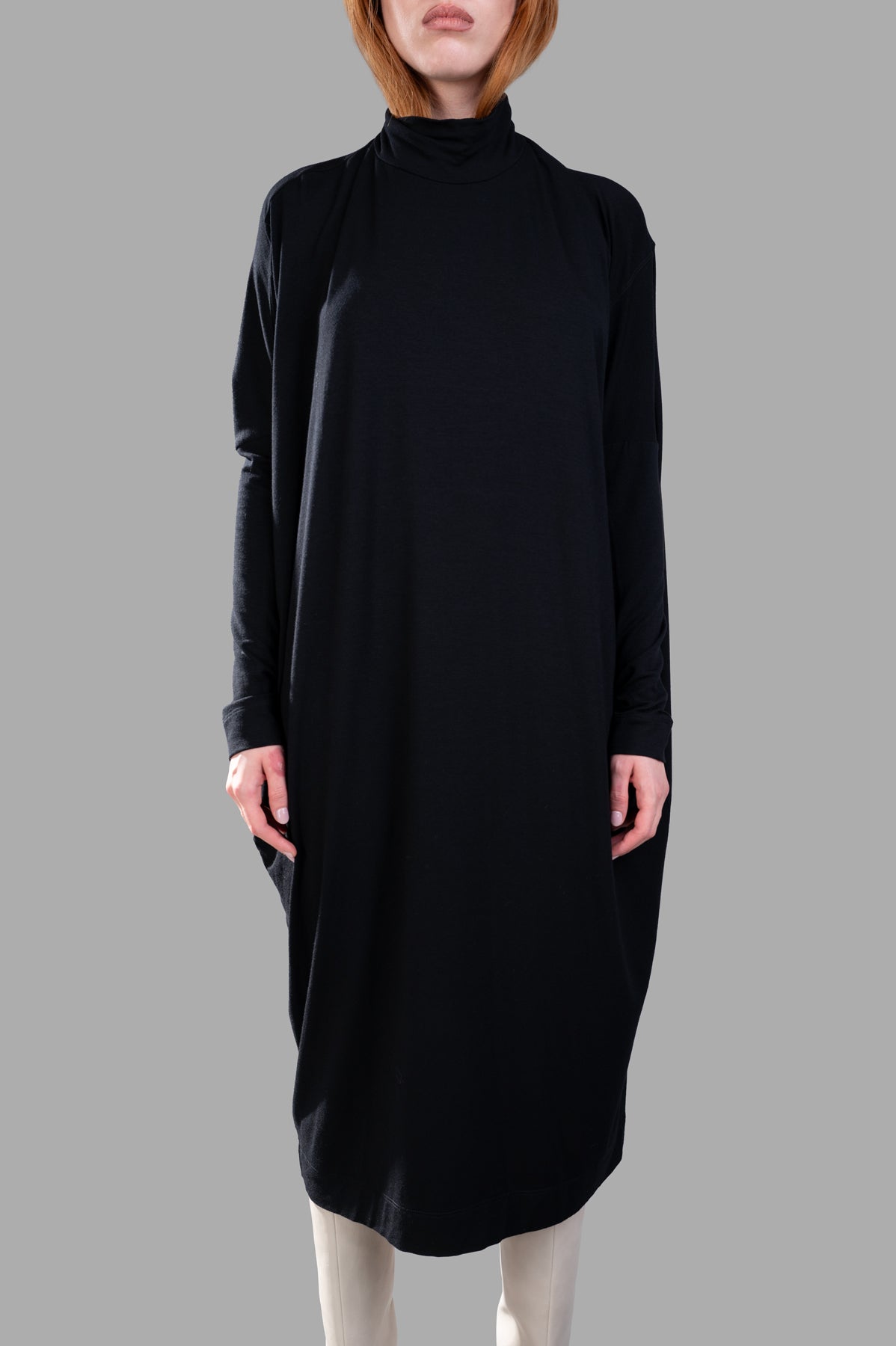 Gentry Portofino Oversized Midi Dress in black, featuring a balloon silhouette, turtleneck, and dropped shoulders, worn on.