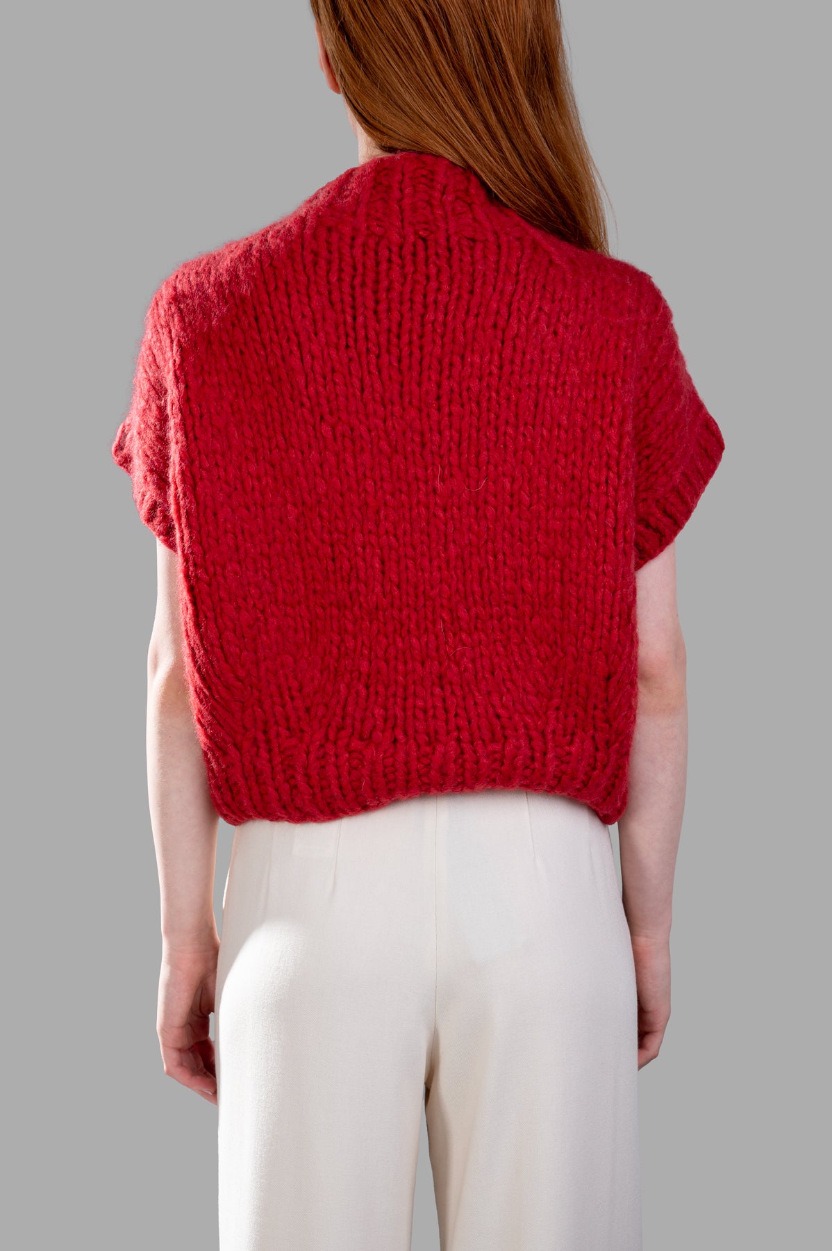 Gentry Portofino Chunky Knit Vest in red, featuring cozy cap sleeves and textured back, perfect for seasonal layering.