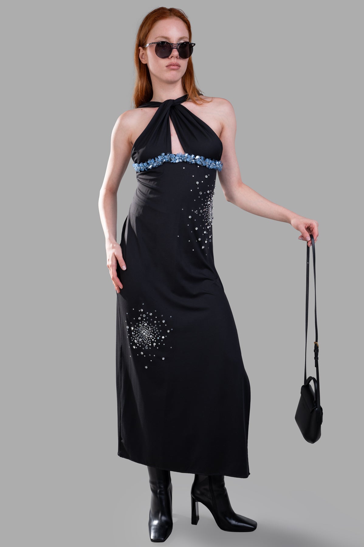 DES PHEMMES Halterneck Dress in black with deep slit, bedazzled details, and flattering front view on model wearing sunglasses.