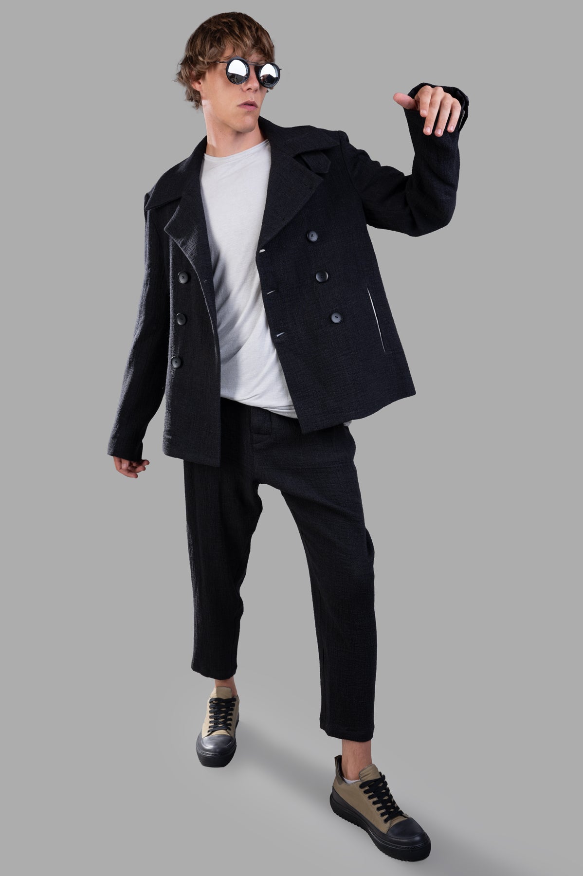Marc Point Double-breasted Jacket on-model, featuring wide lapels, black buttons, paired with casual pants against gray.