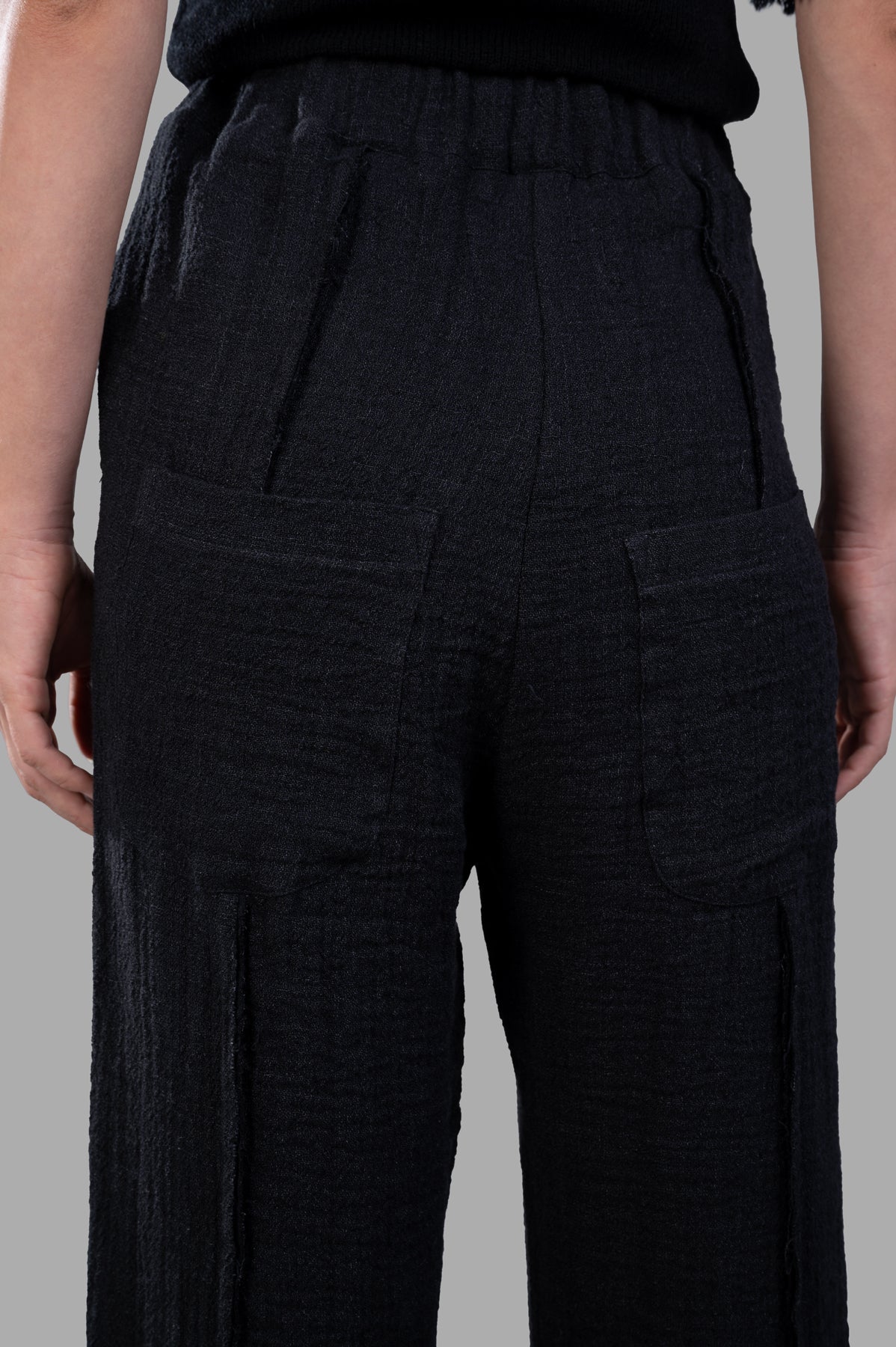 Marc Point Textured Trousers featuring back pleats and pockets, highlighting the flattering high-waisted design in black.