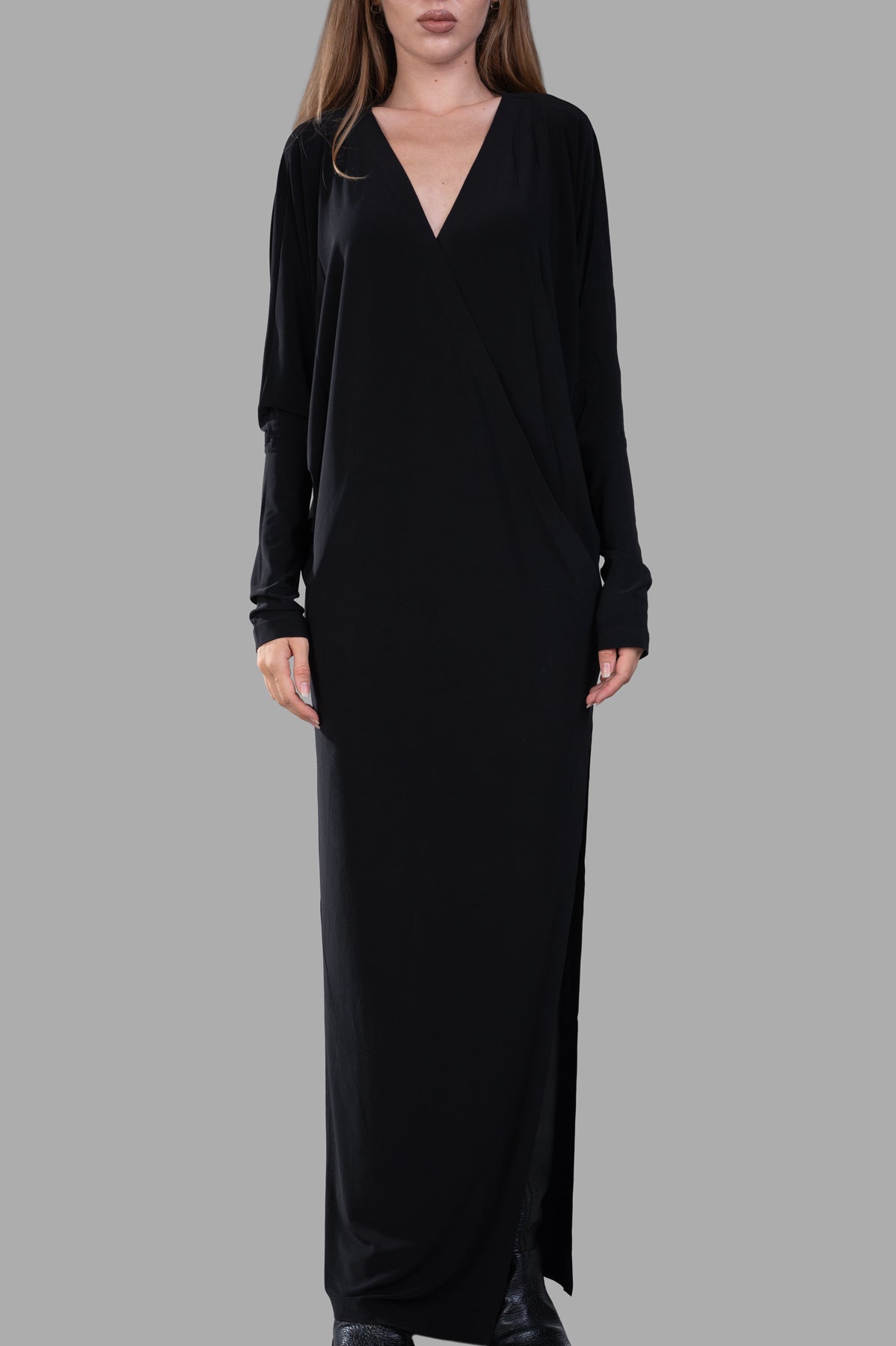 Norma Kamali Dolman Wrap Gown in black, featuring a v-neckline, side slit, and elegant dolman sleeves on model.