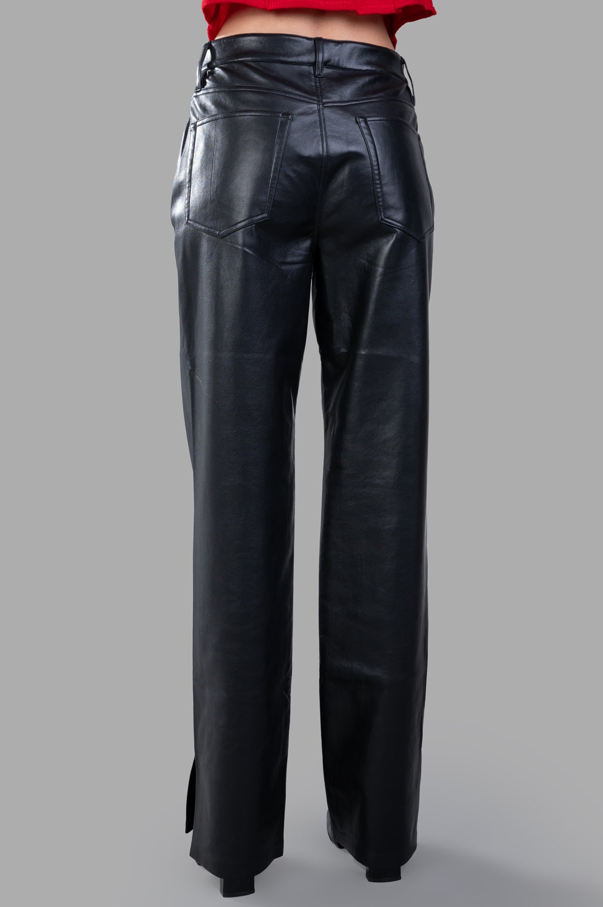 Anine Bing Roy Pants, black regenerated leather trousers shown from the back, featuring side slits and a relaxed fit.