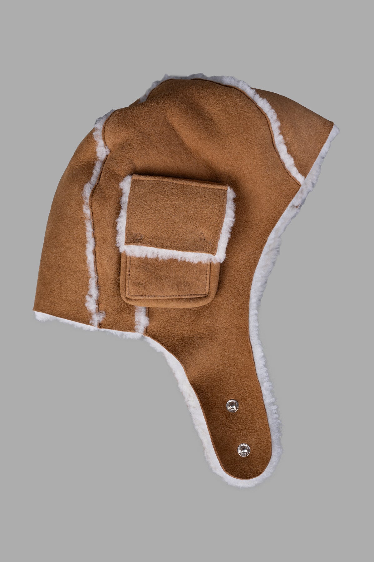 Natasha Zinko Shearling Camping Hat featuring aviator-style design with earflaps in brown faux fur shearling, side view.