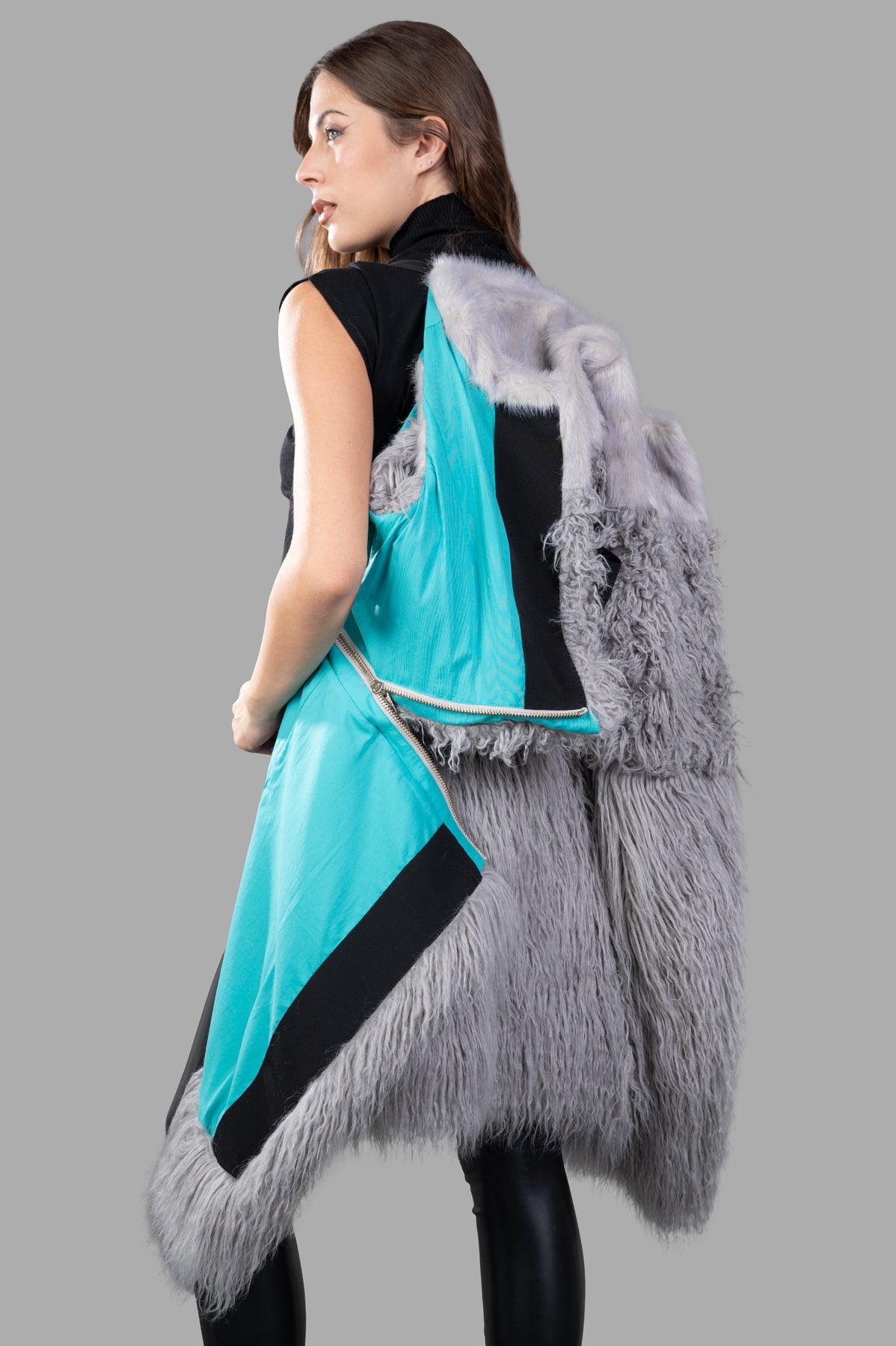 Alabama Muse Faux-fur Vest in grey, cropped style shown on model from the back, featuring vibrant turquoise and black accents.