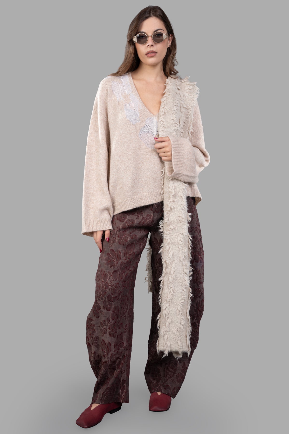 Uma Wang beige long-sleeve sweater on model, featuring marl knit with V-neck, drop-stitch details, and drop shoulders.