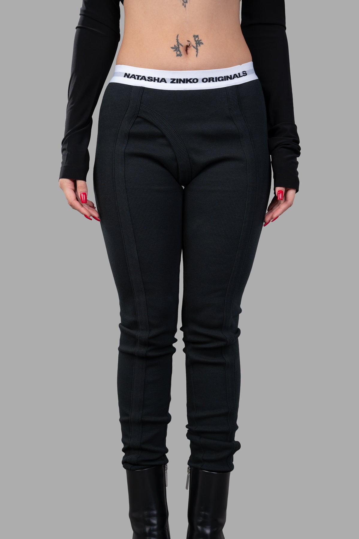 Natasha Zinko Jersey Leggings in black, featuring a logo waistband and detailed stretch cotton fabric, showcased on model.