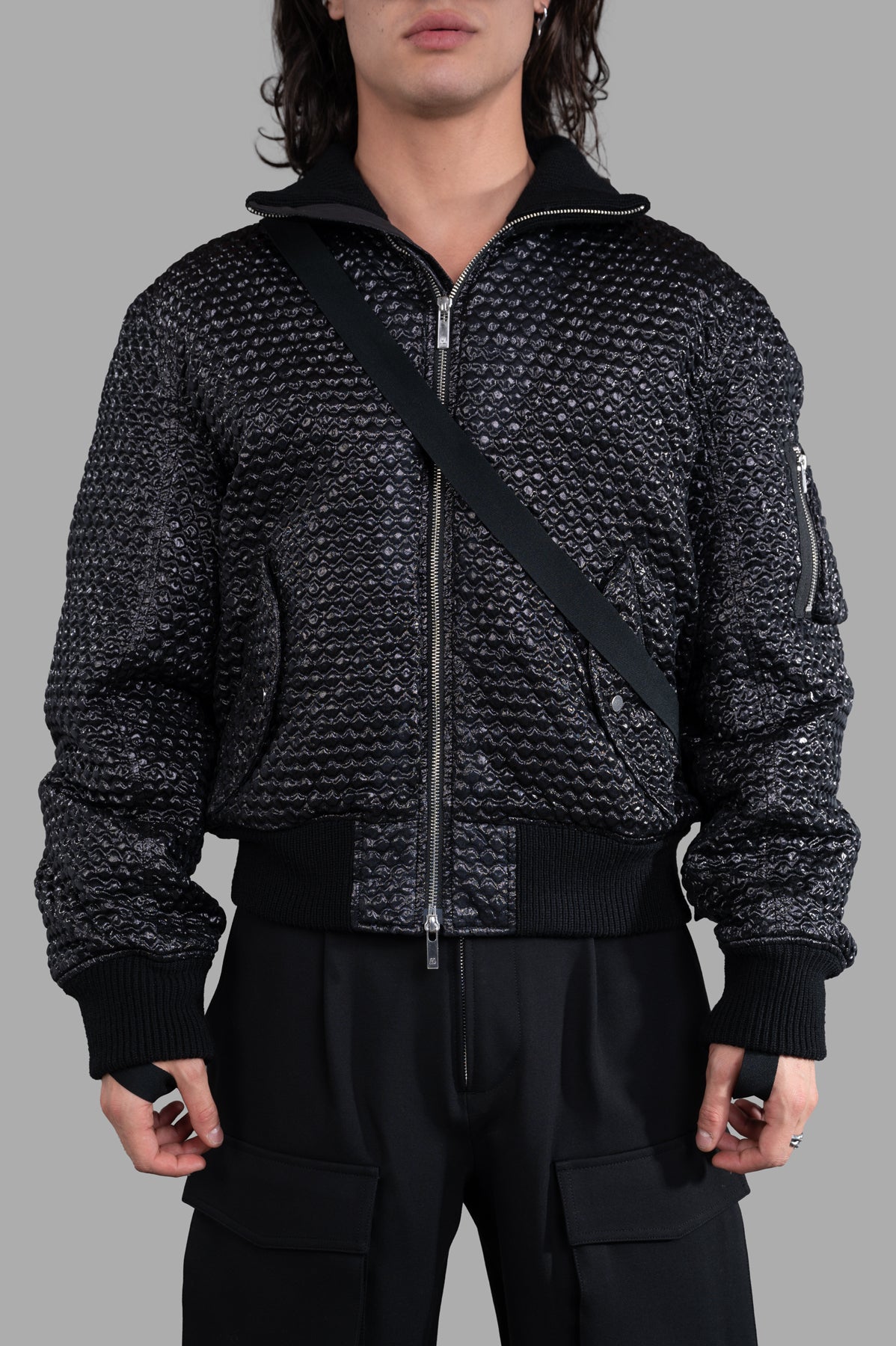 Helmut Lang Seatbelt Bomber jacket features a sculptural jacquard with 3D bubblewrap texture, shown in black on model.