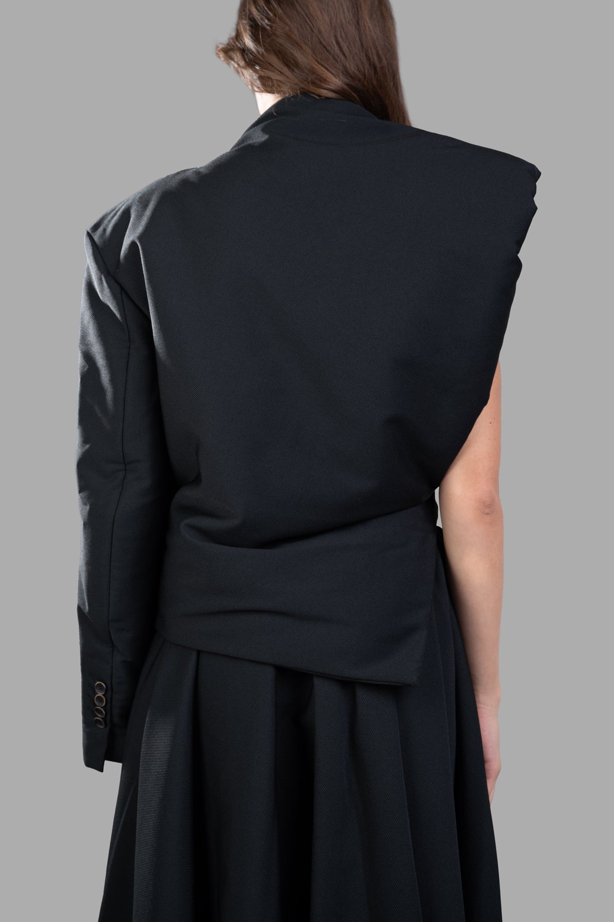 Uma Wang Padded Asymmetric Top featuring a chic half-jacket design from the back, showcasing a cinched waist in black.
