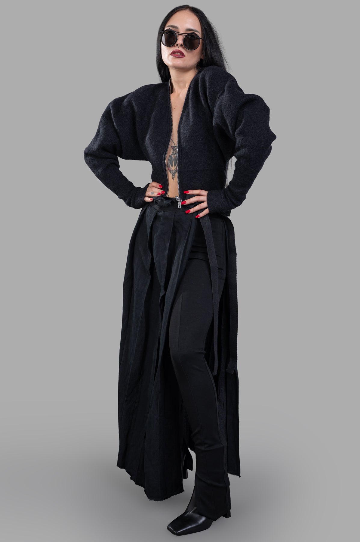Masnada Pleated Maxi Skirt shown from the front on model, paired with leggings for a stylish layered look.