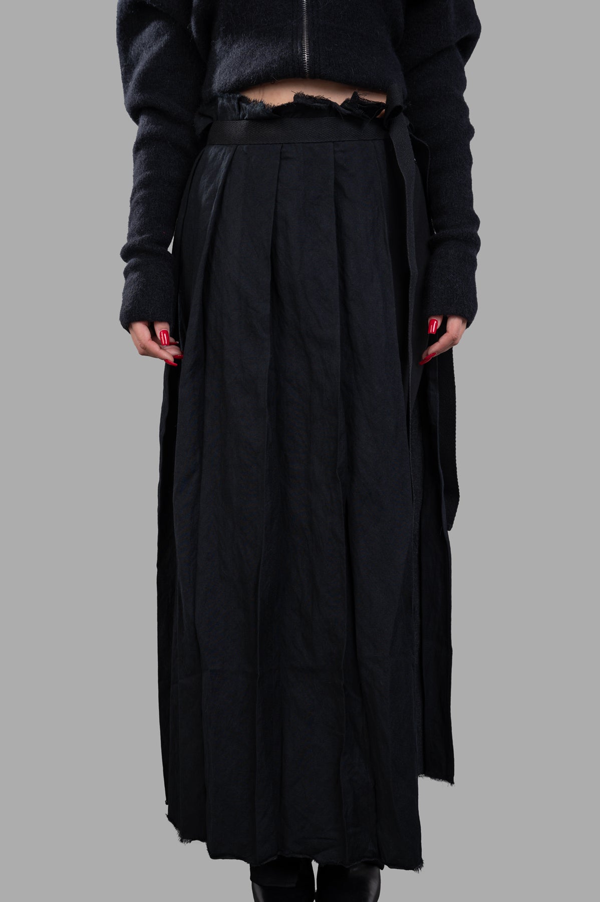 Masnada Pleated Maxi Skirt shown on model, featuring elegant pleats and a comfortable fit in soft black fabric.