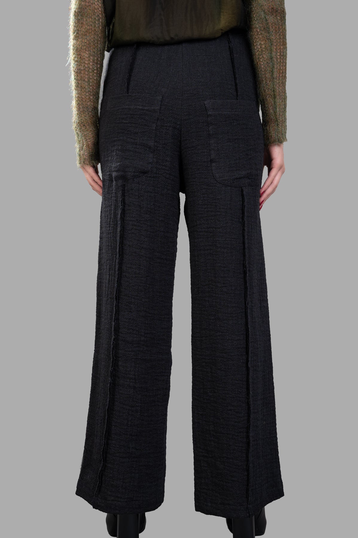 Marc Point Front-pleat Pants in black, showcasing high waist and back pockets from a rear view, highlighting texture and fit.