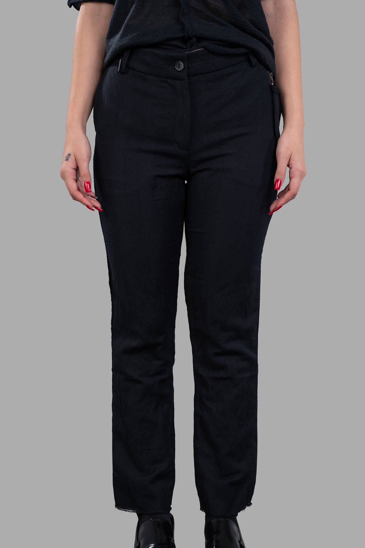 Masnada Slim-cut Trousers in black, featuring a concealed side zip and frayed hem, showcased on a model from the front.