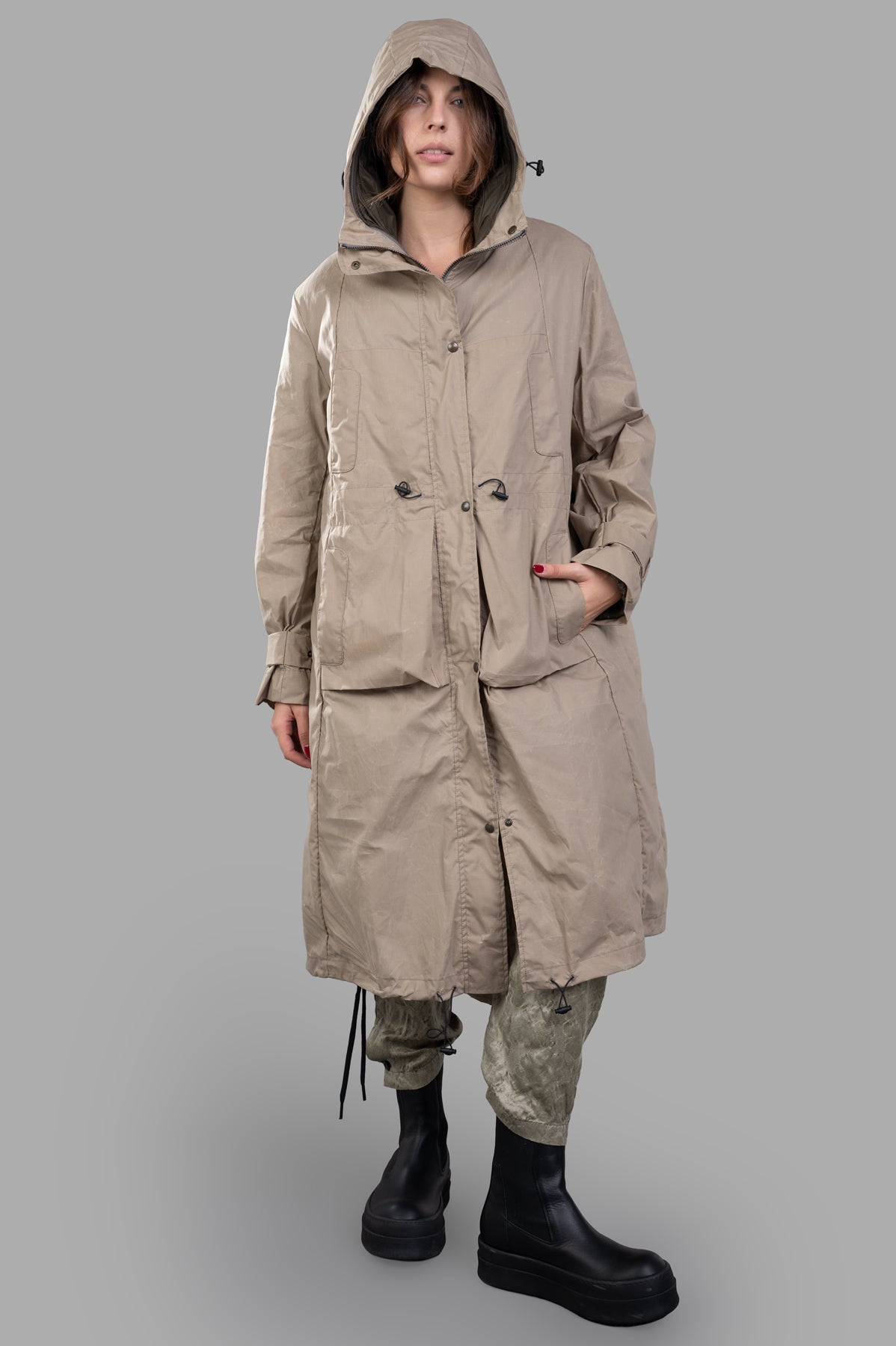 Masnada Layered Raincoat in beige with drawstring hood and belted cuffs, front view on model. Ripstop texture.