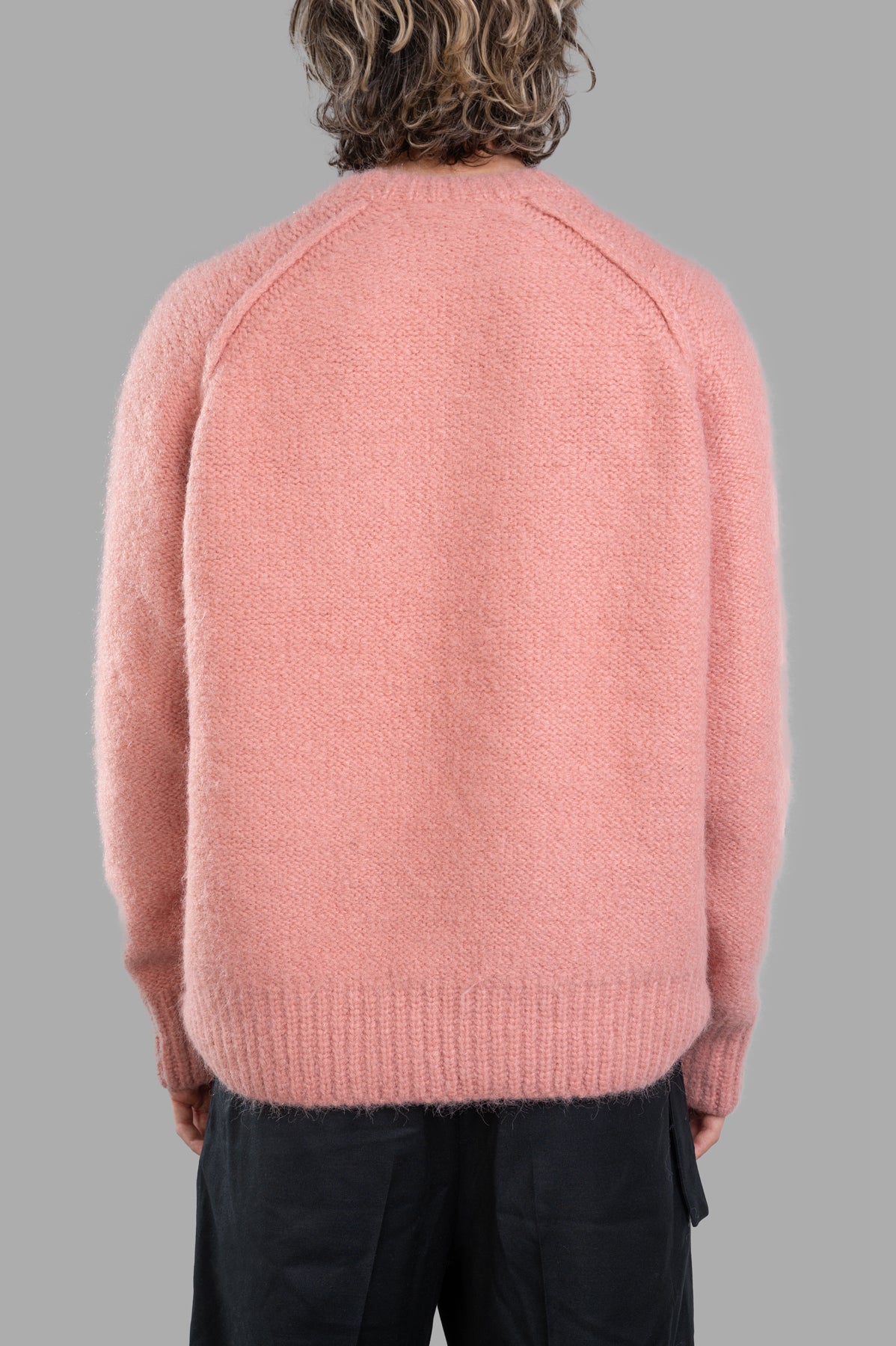 Vein. Oversized Sweater in soft pink, showcasing the back view with textured fabric and ribbed hem detail.