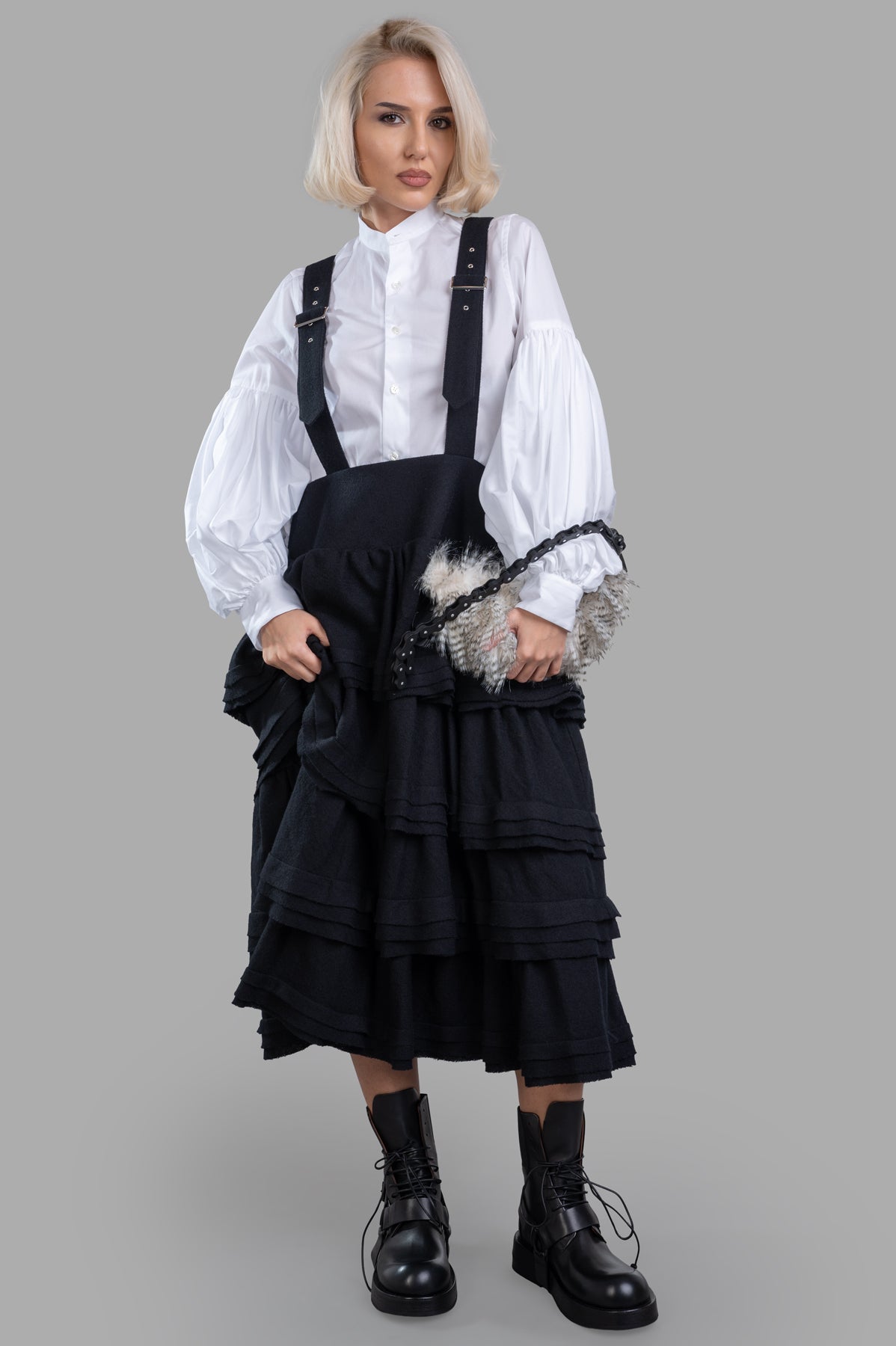 Noir Kei Ninomiya wool suspender dress with ruffled tiers and harness straps, in black, front view on model.
