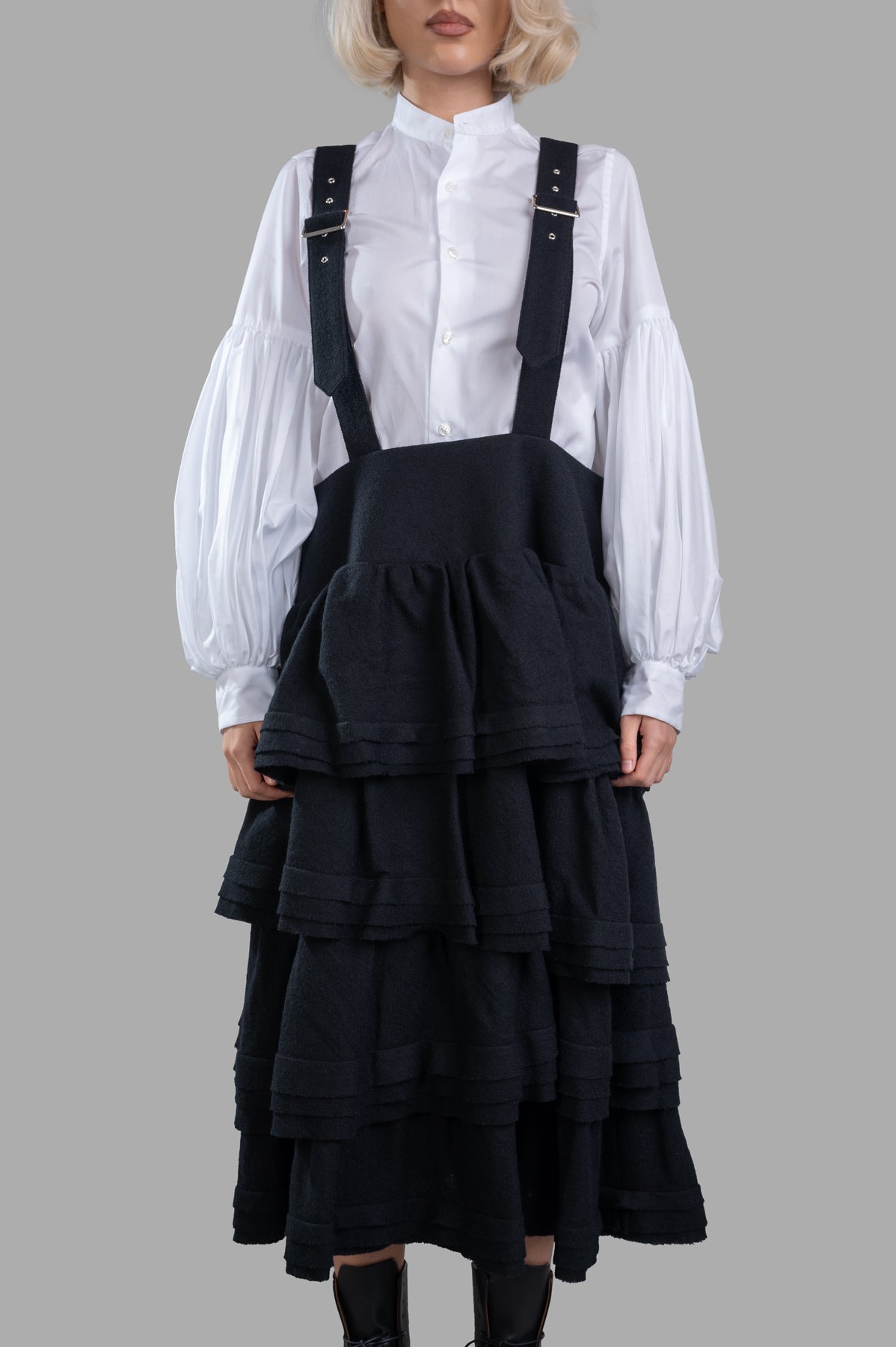 Noir Kei Ninomiya Wool Suspender Dress featuring ruffled tiers and harness straps, seen on-model with a white blouse.