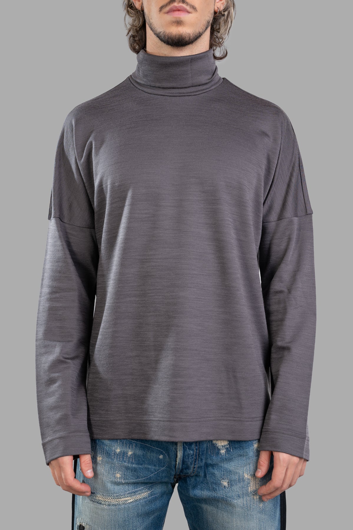 Attachment Turtleneck Top in grey, featuring long sleeves and a sleek design, showcased on a model. Made of wool and nylon.