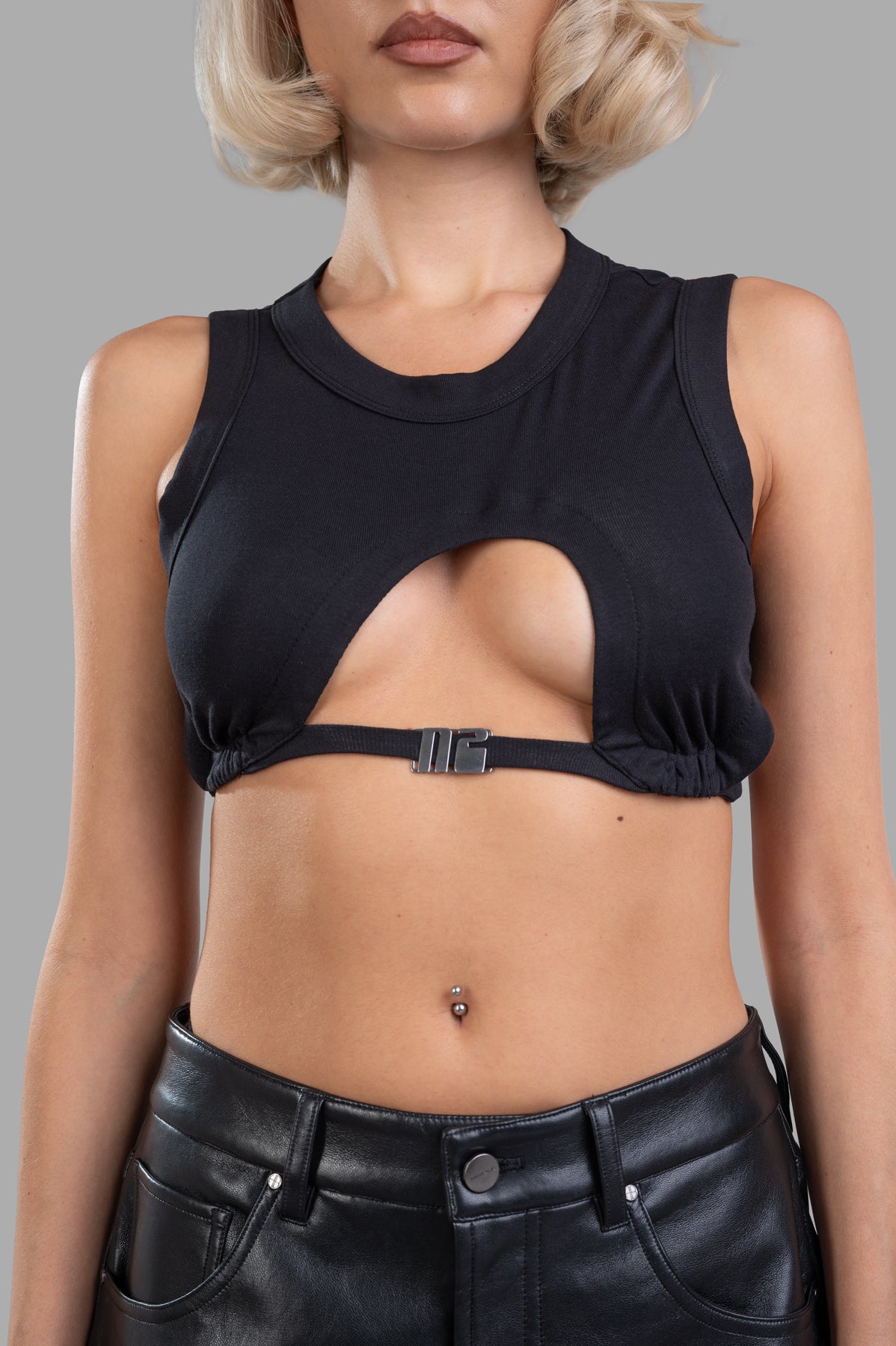 Natasha Zinko Cropped Cutout Top in black, featuring daring cutout detail and a round neckline, styled on a model.