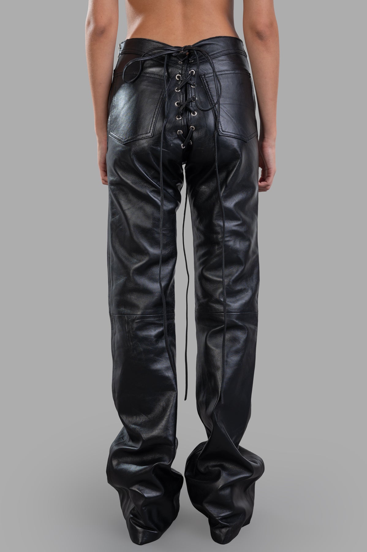 Natasha Zinko Lace-Up Leather Pants featuring a back view with detailed lace-up design and relaxed straight-leg cut in black.